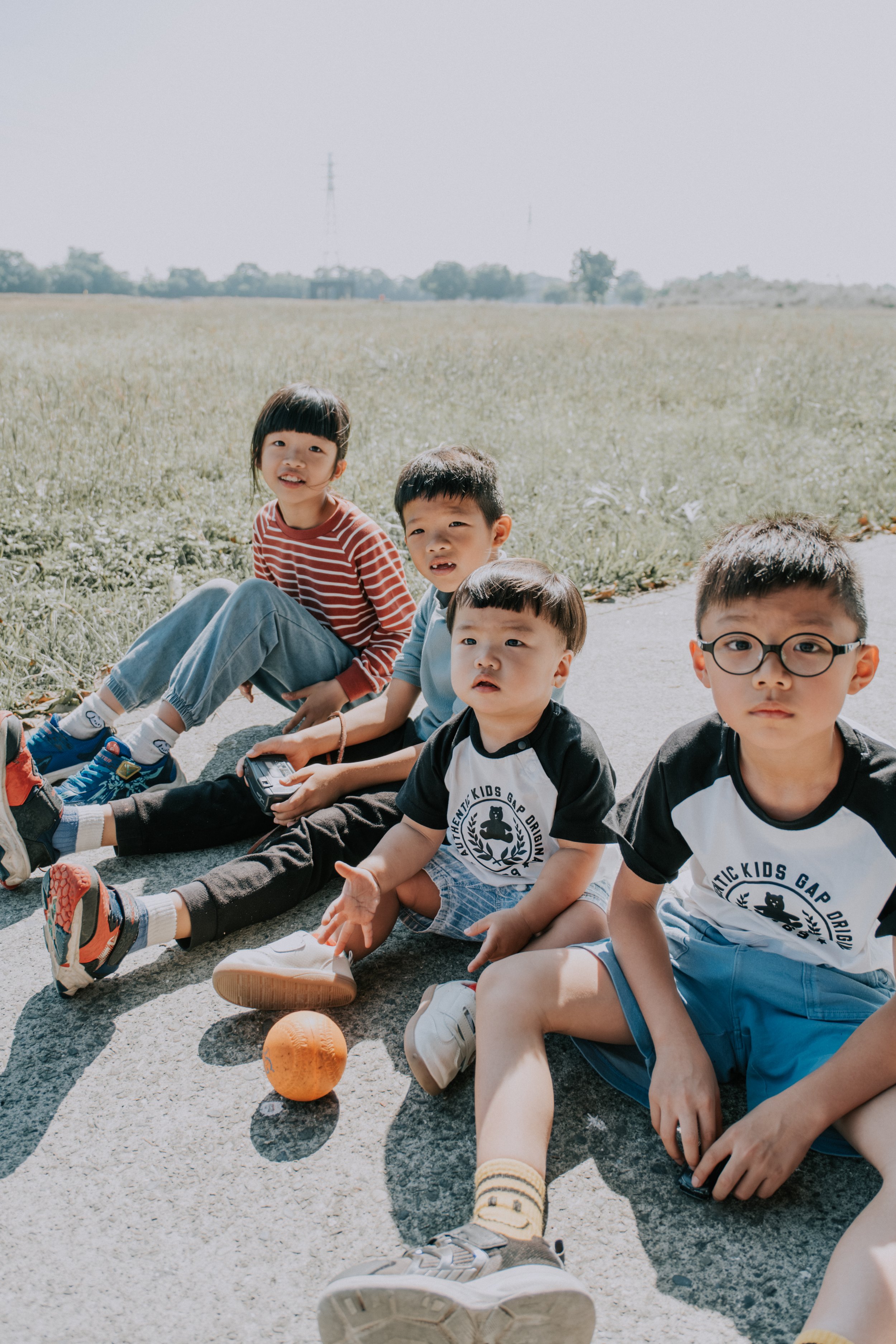 台中兒童團體寫真｜一群男孩坐在田野間的道路上，自然輕鬆的戶外童年生活紀錄
