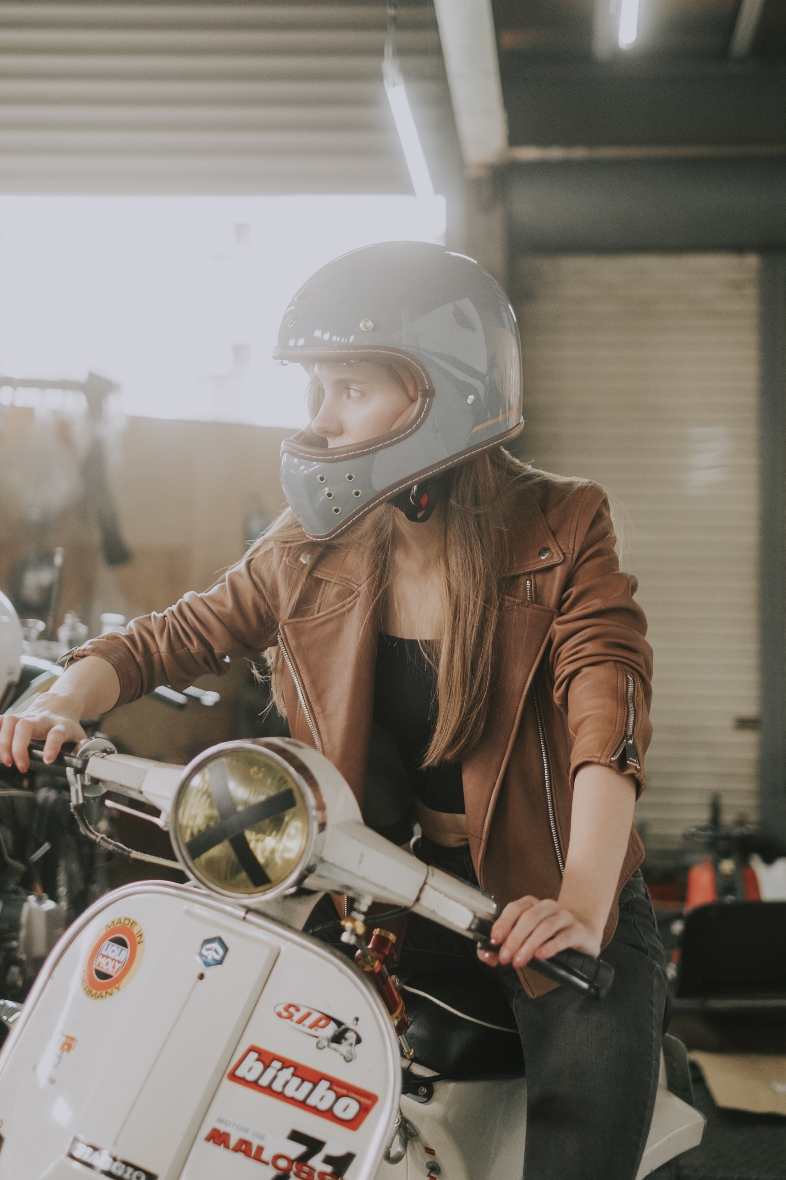 商業攝影｜女生穿棕色皮衣戴白色全罩式安全帽騎車，品牌形象寫真拍攝