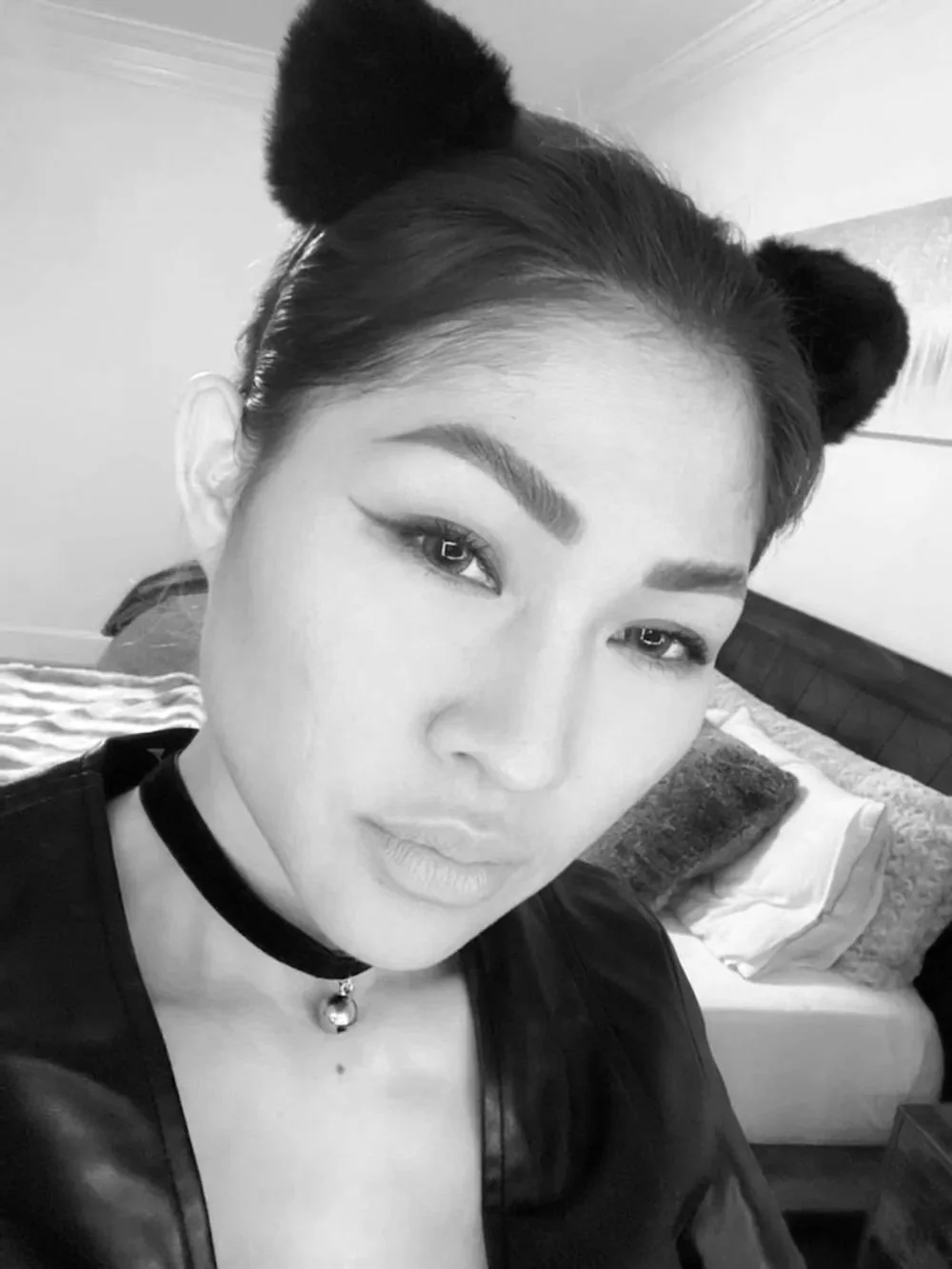 Black-and-white selfie of Trang T. Nguyen wearing cat ears and a choker necklace.