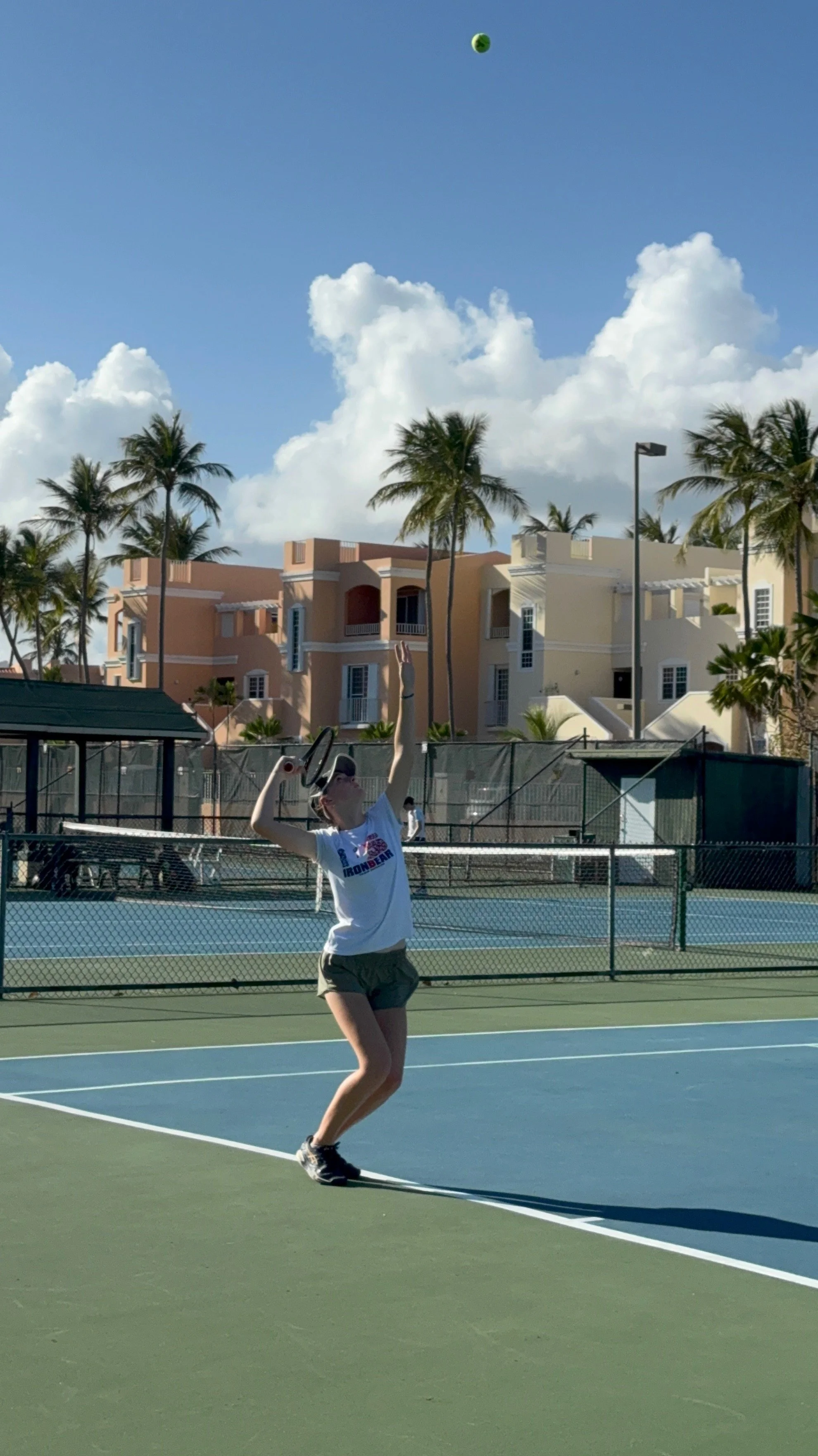 A person playing tennis on an outdoor court in Puerto Rico