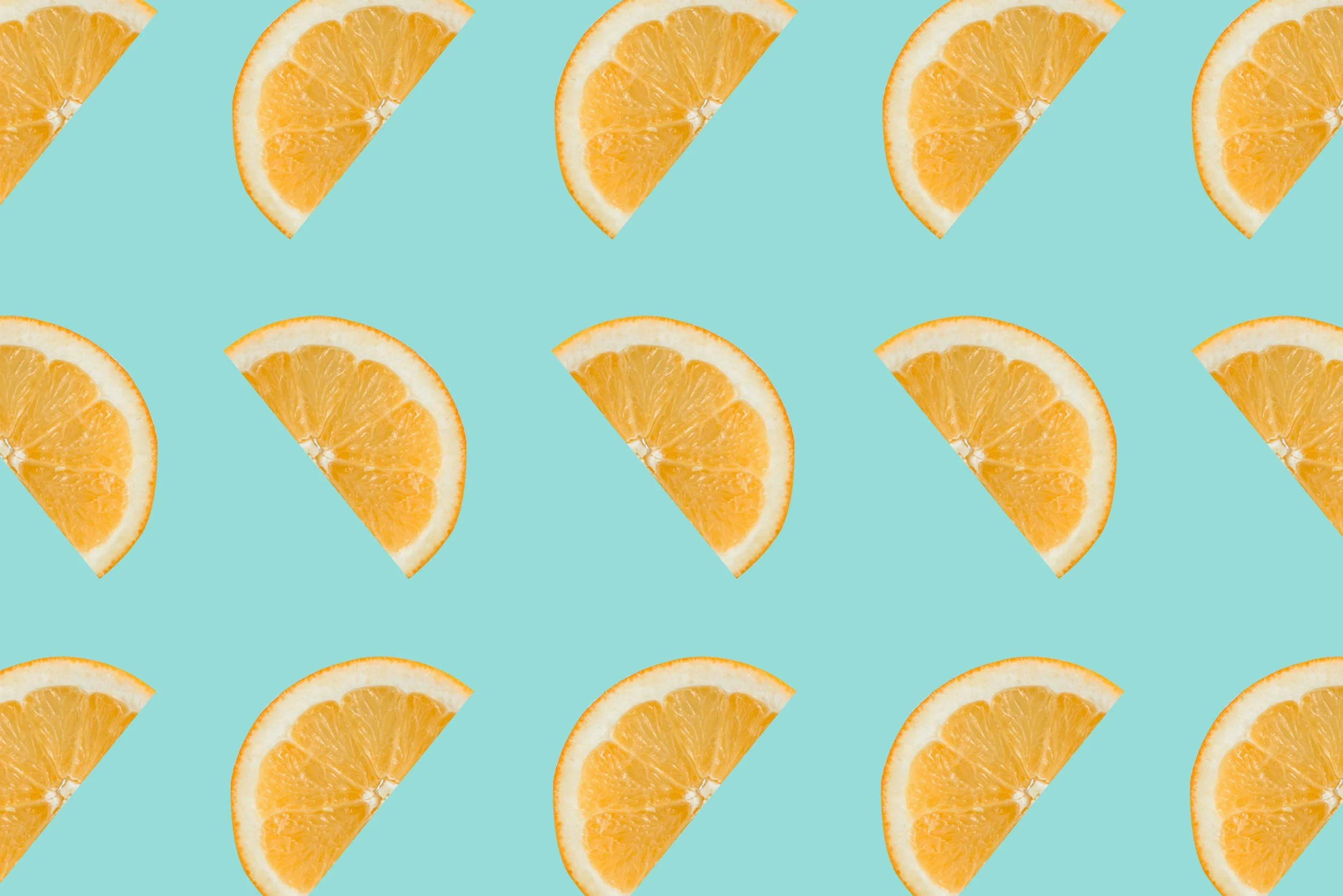 Pattern of orange slices on a light blue background, with some slices facing up and others facing sideways.