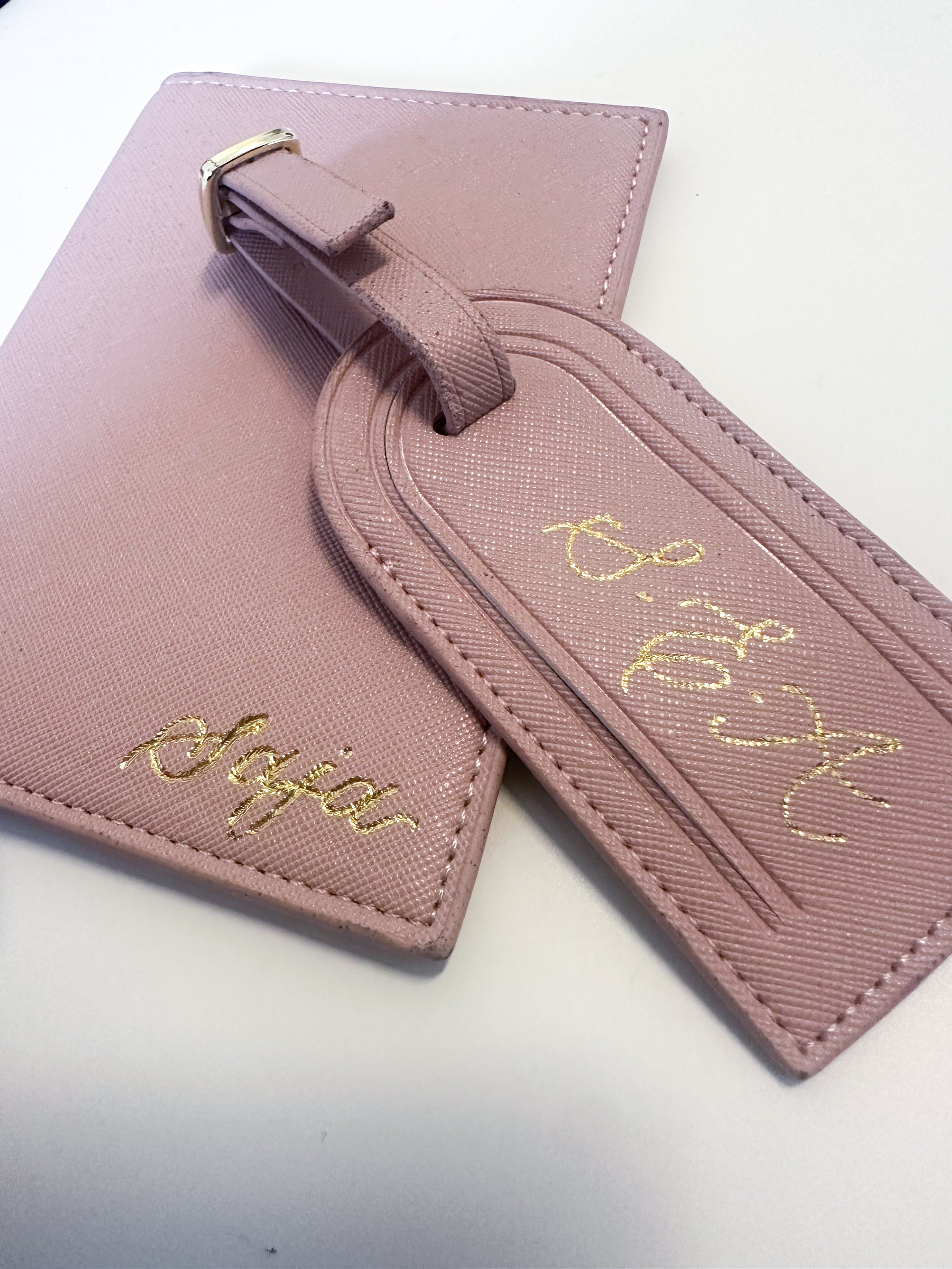 Pink leather luggage tag with gold embroidery and a pink leather strap