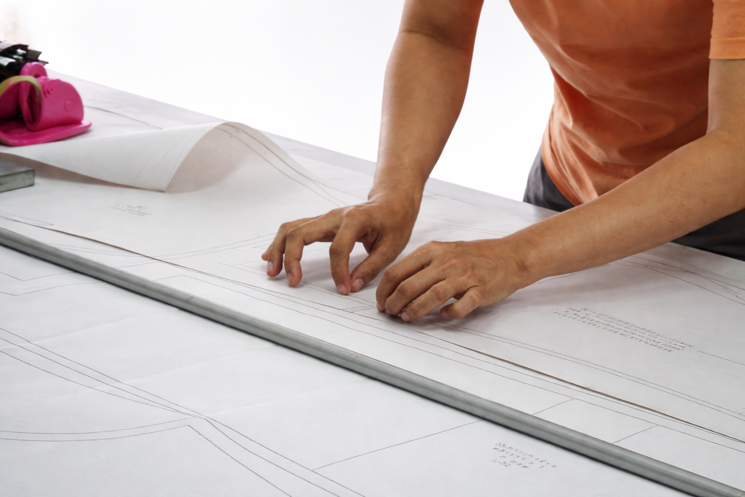 Garment pattern preparation on cutting table, ensuring accurate sizing and precision before fabric cutting.