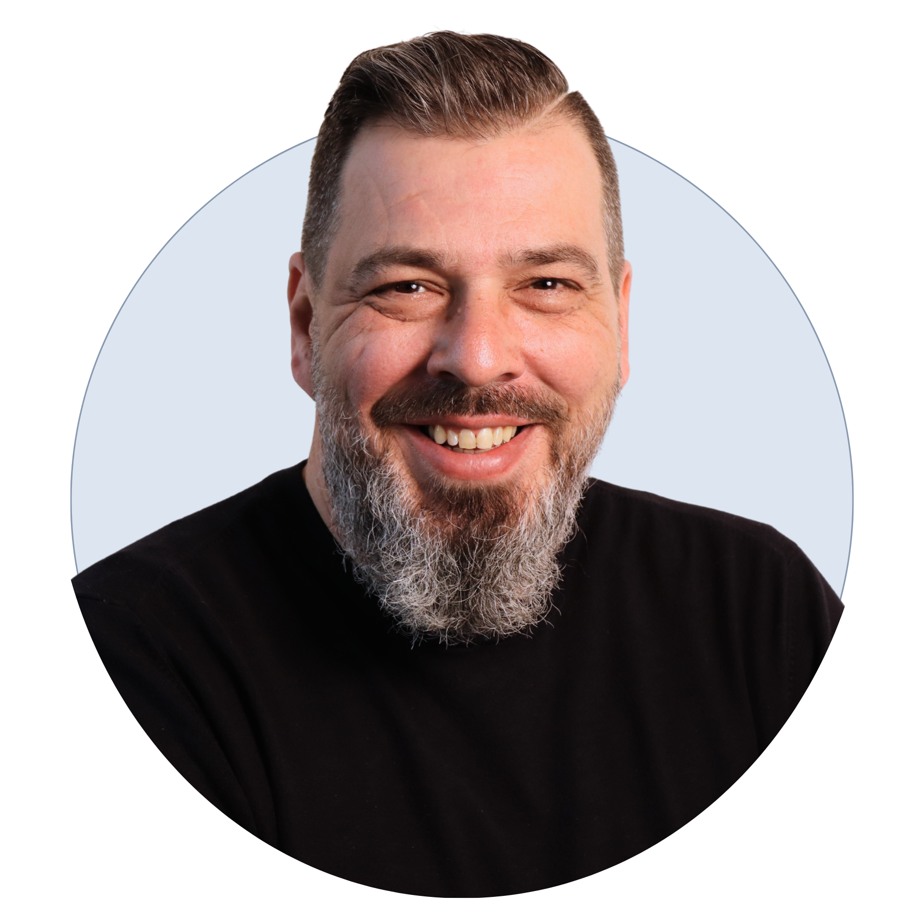 A smiling man with a beard and short hair, wearing a black shirt, against a light background.