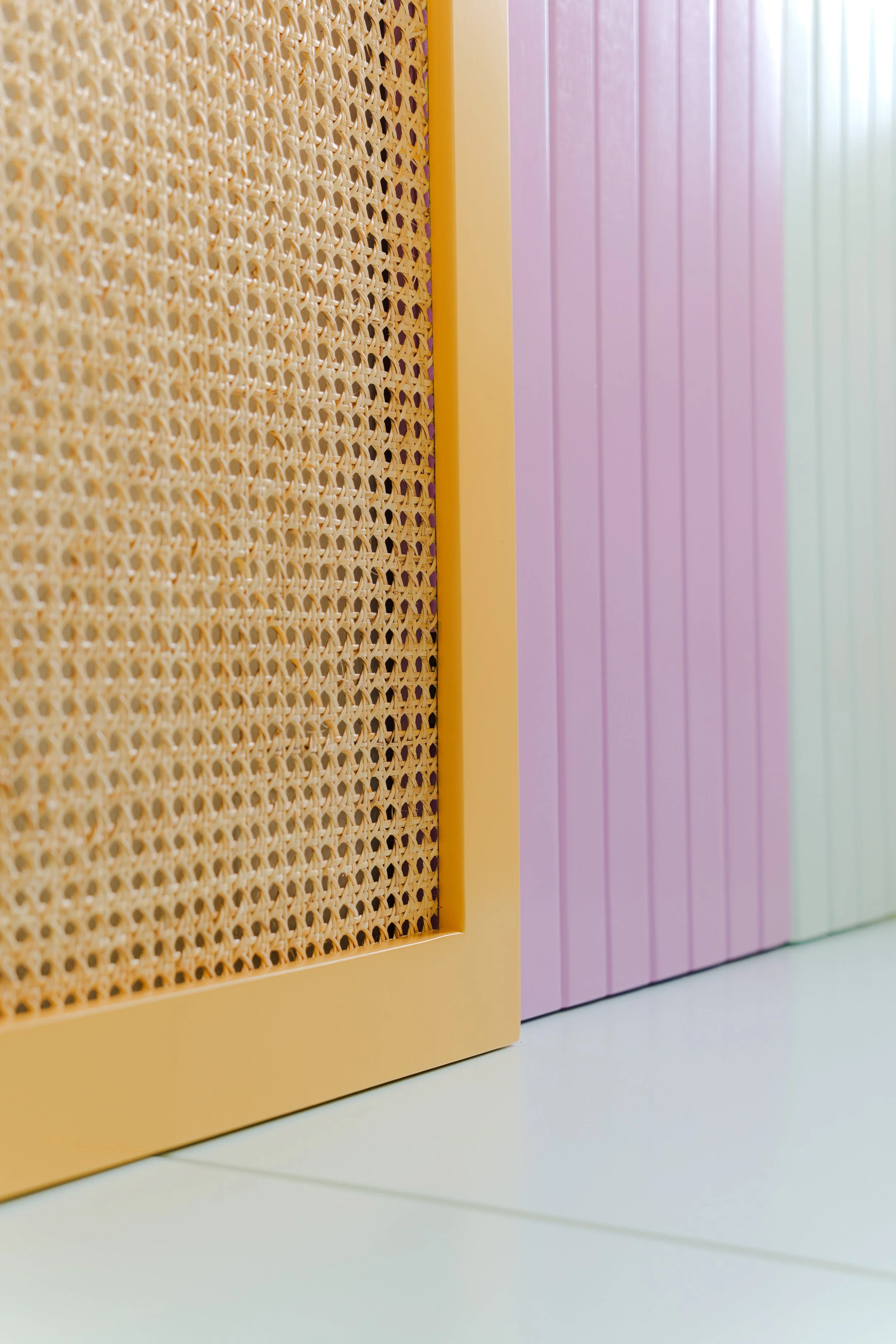 Detalles de muebles en colores pastel con superficie lisa y paneles de rejilla de mimbre