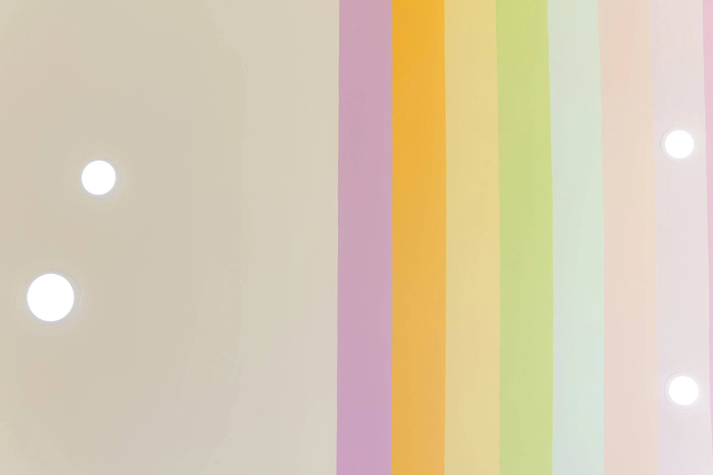 Techo colorido con varias tiras de colores pasteles y luces empotradas