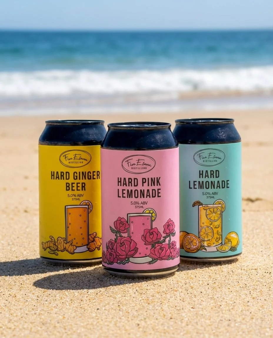 3 cans of Five Eleven hard lemonade and ginger beer on the beach
