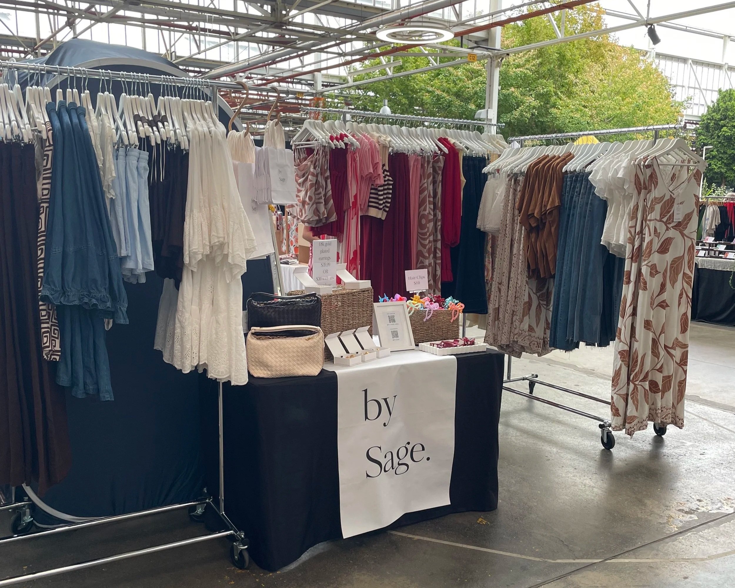 By Sage clothing and items on racks and table