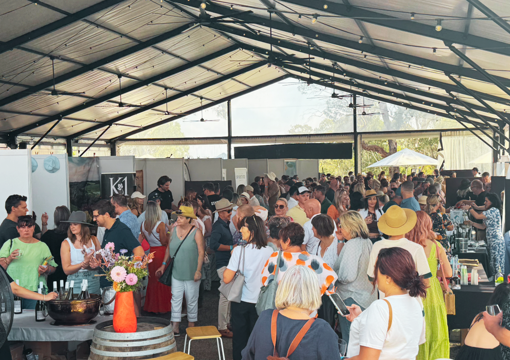 Guests connecting with food and wine producers at a busy tasting event