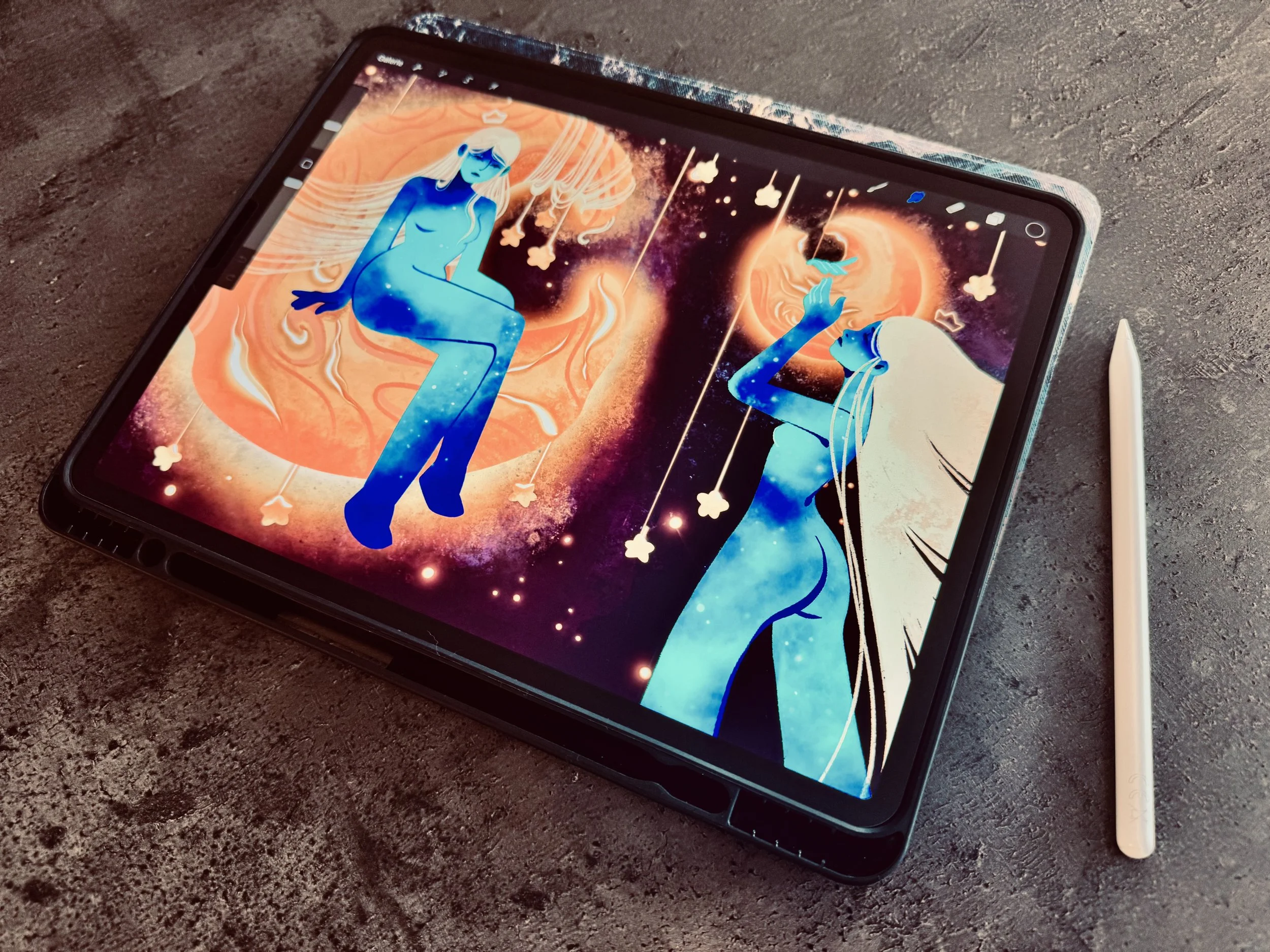 Une tablette numérique affichant une illustration artistique d'une femme bleue flottant dans un espace coloré avec des étoiles et des planètes, accompagnée d'un stylet blanc placé à côté.