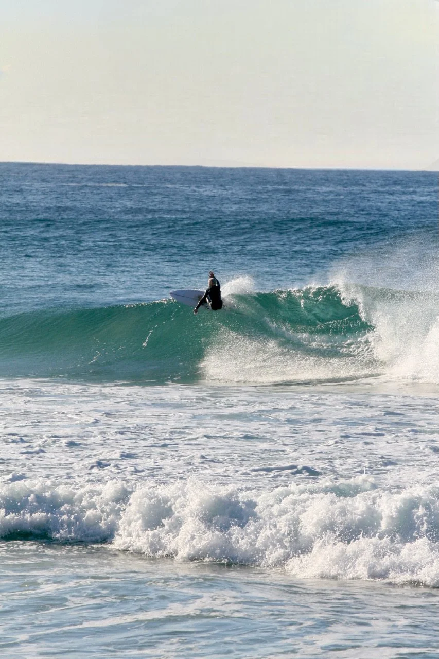 A person surfing on a wave in the ocean.