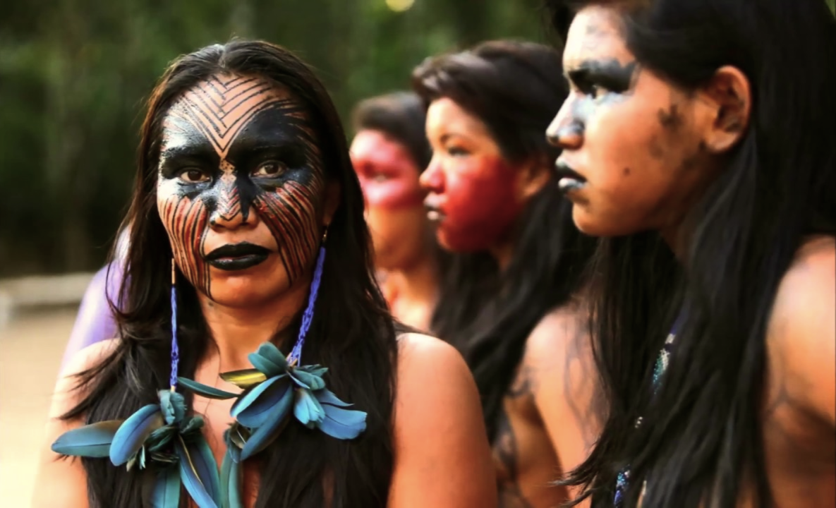 Grupo de personas con pintura facial tradicional en un entorno natural.