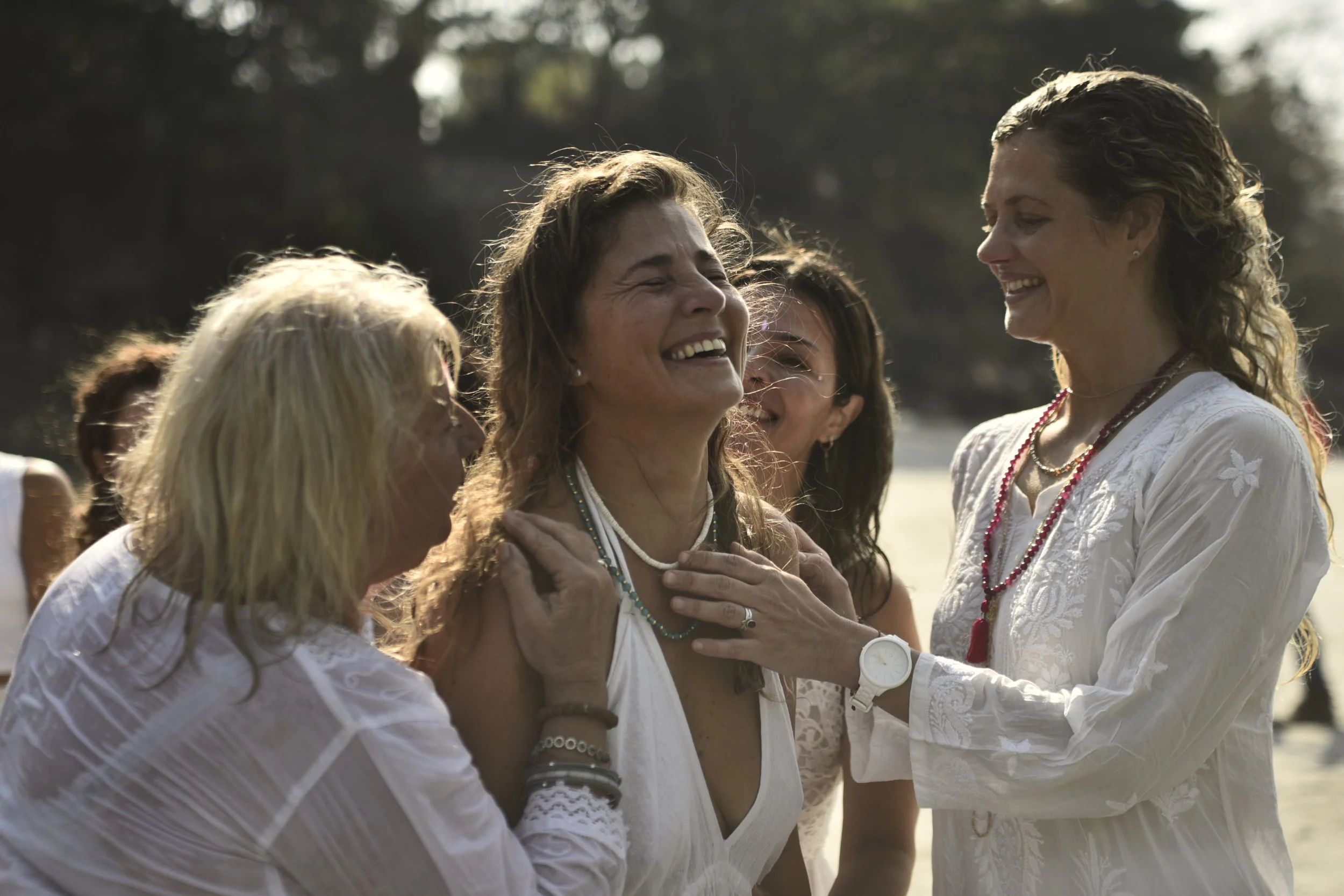 Grupo de mujeres sonriendo y compartiendo un momento alegre al aire libre.