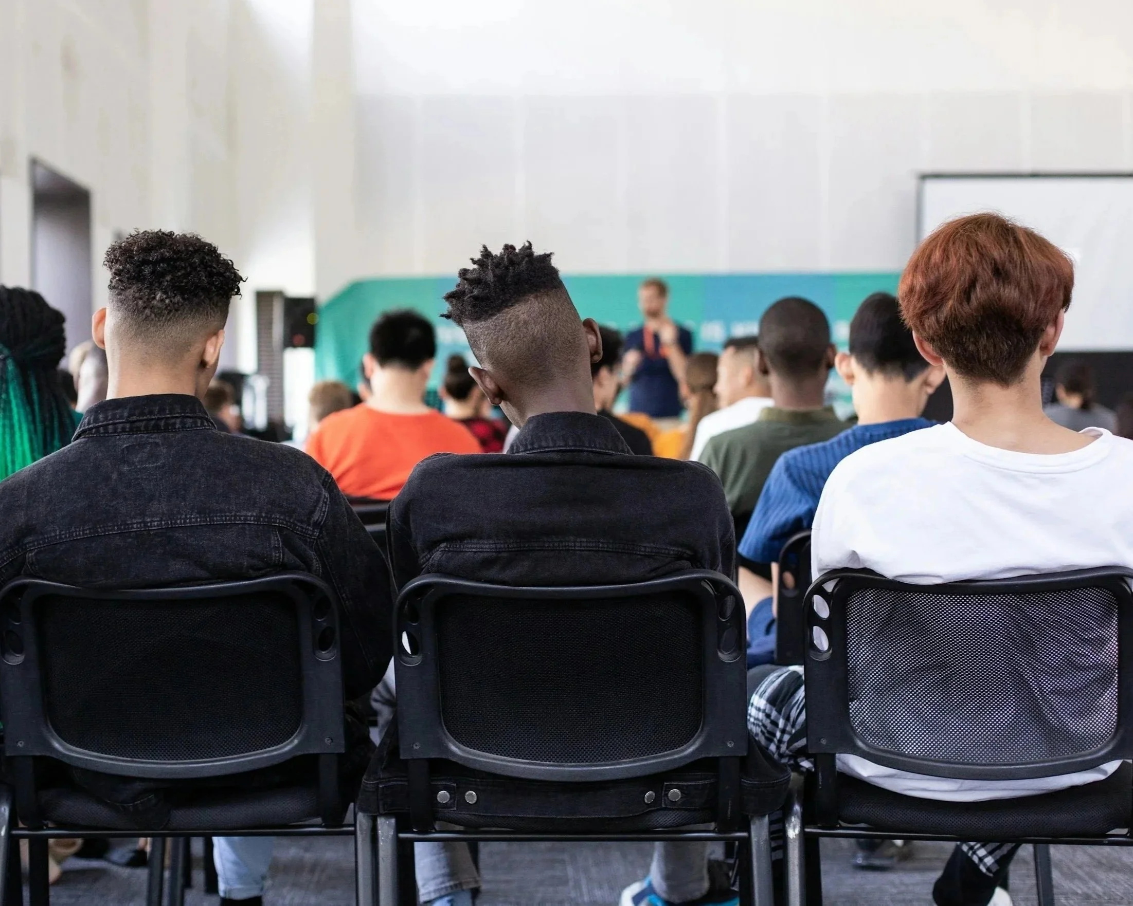 Students seated in a classroom attending a lecture or presentation. This picture supports our section on how we support Diversity and in particular Social Mobility. We work with charities in inner city schools to improve social mobility.