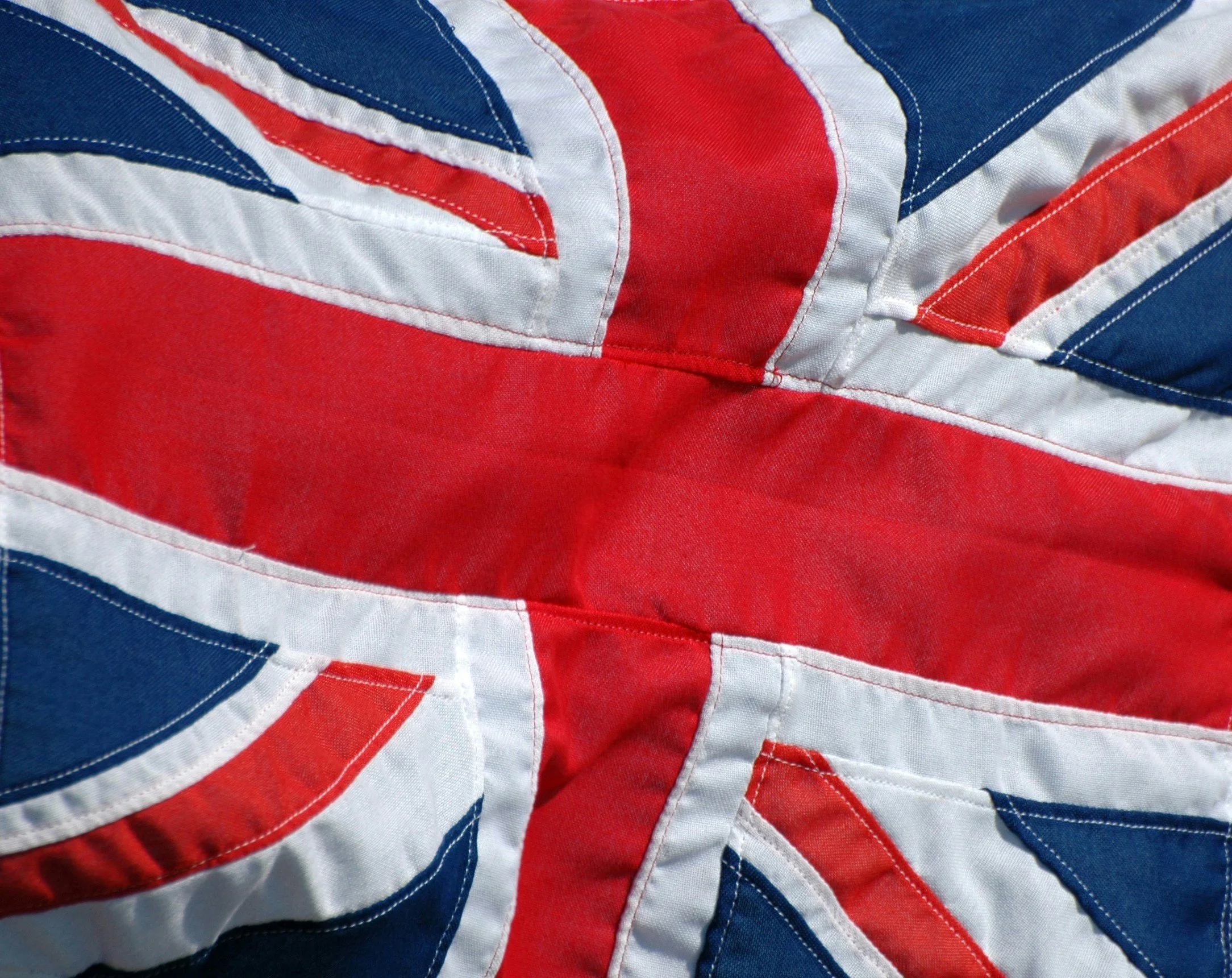 Close-up view of a fabric with a design resembling the Union Jack, the national flag of the United Kingdom, using red, white, and blue patches.