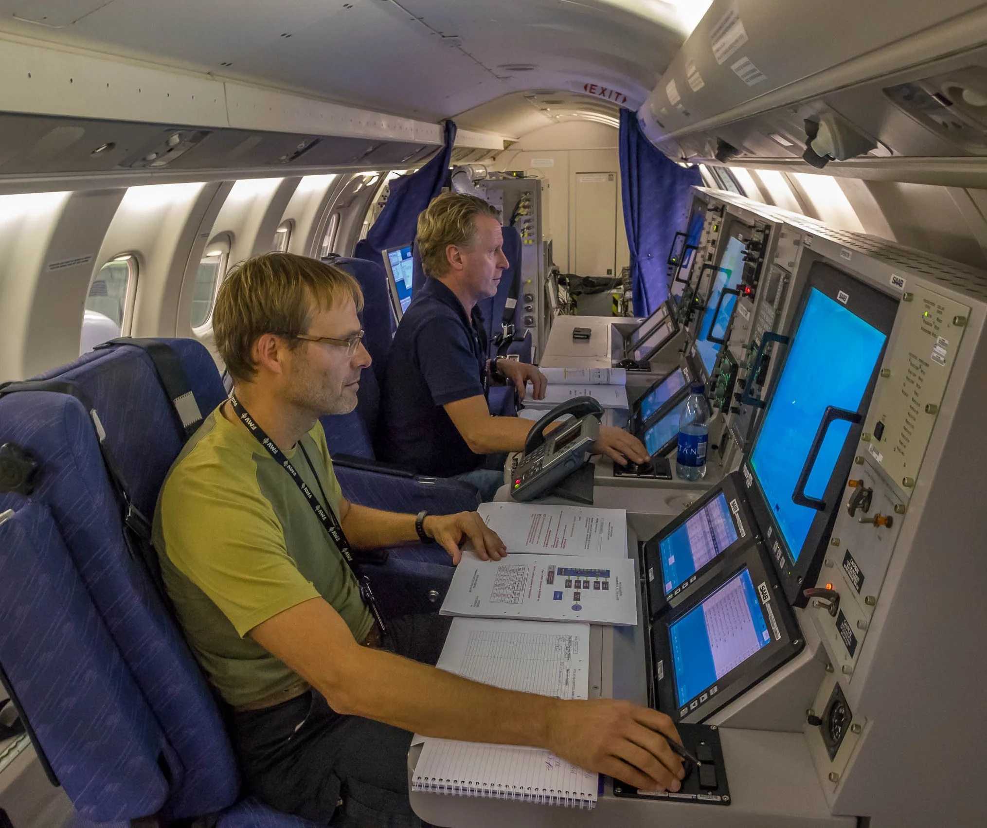 2 Technicians working on sceens inside an aircraft