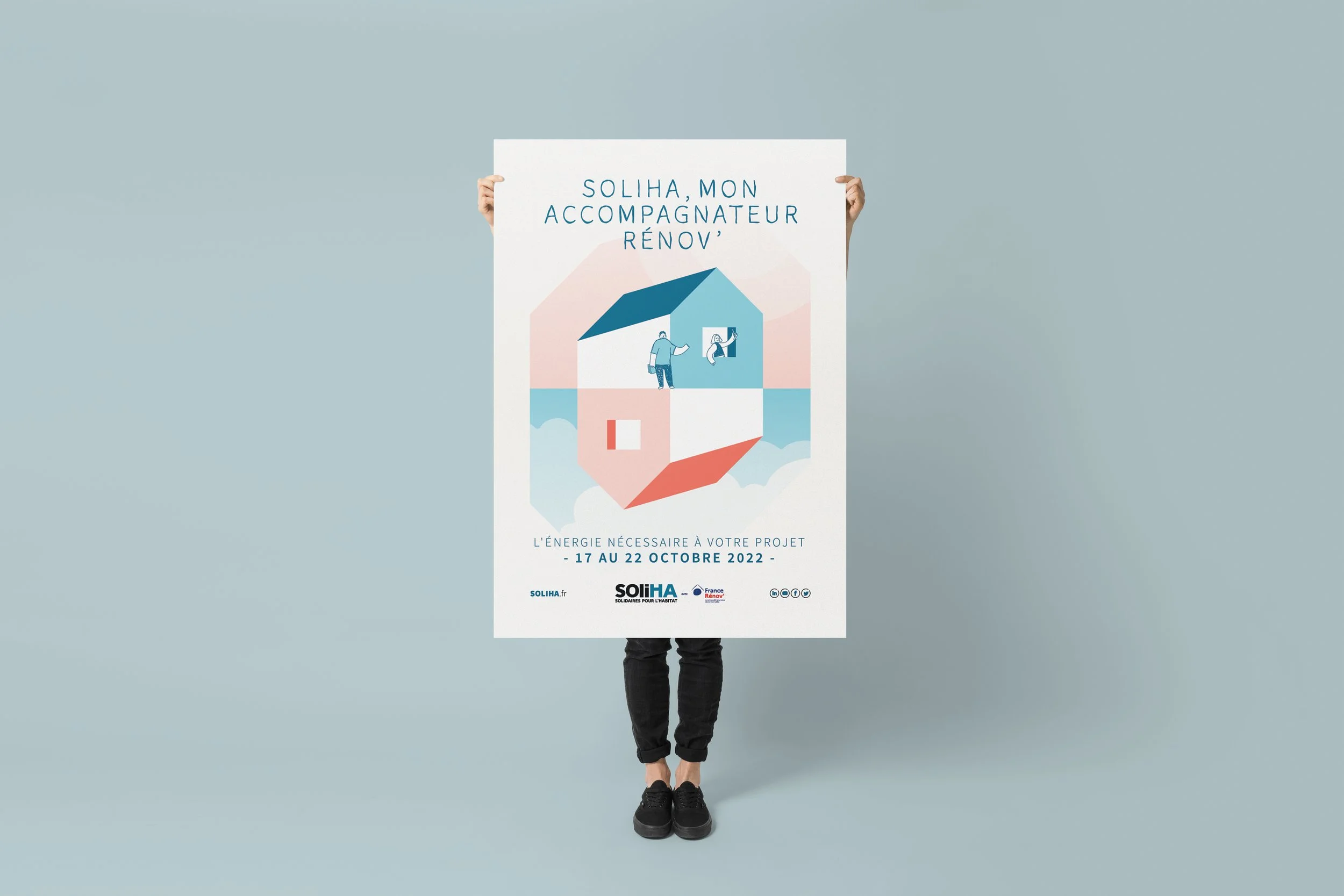 Une personne tient une affiche de couleur claire avec un design géométrique et du texte en français. Le design inclut une maison stylisée en origami, avec des illustrations de personnes à l'intérieur. Le texte sur l'affiche mentionne 'Soliha, mon acc