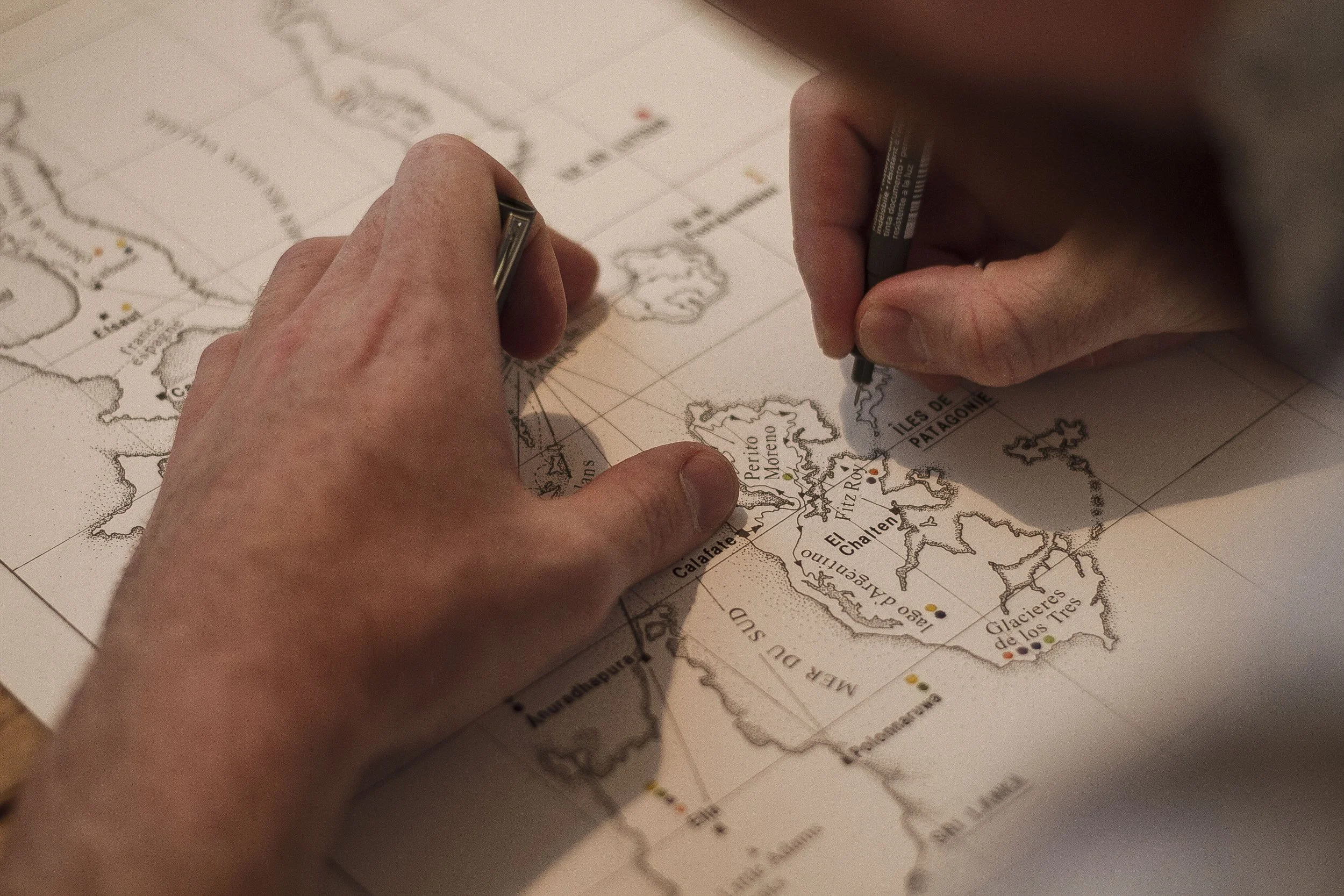 Personne en train de dessiner ou d'annoter une carte des îles de la Patagonie, notamment l'île de Pâtagonie, l'île Fitz Roy et d'autres régions dans le sud de l'Amérique du Sud.