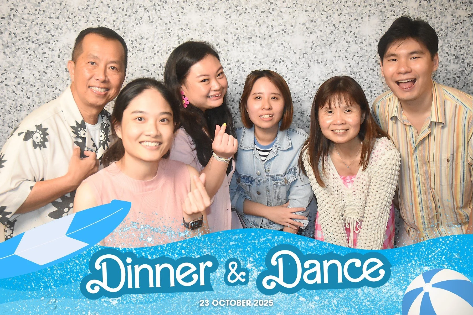 A group of seven people smiling and posing for a photo at a dinner and dance event with a blue banner that says "Dinner & Dance" and the date October 23, 2025.