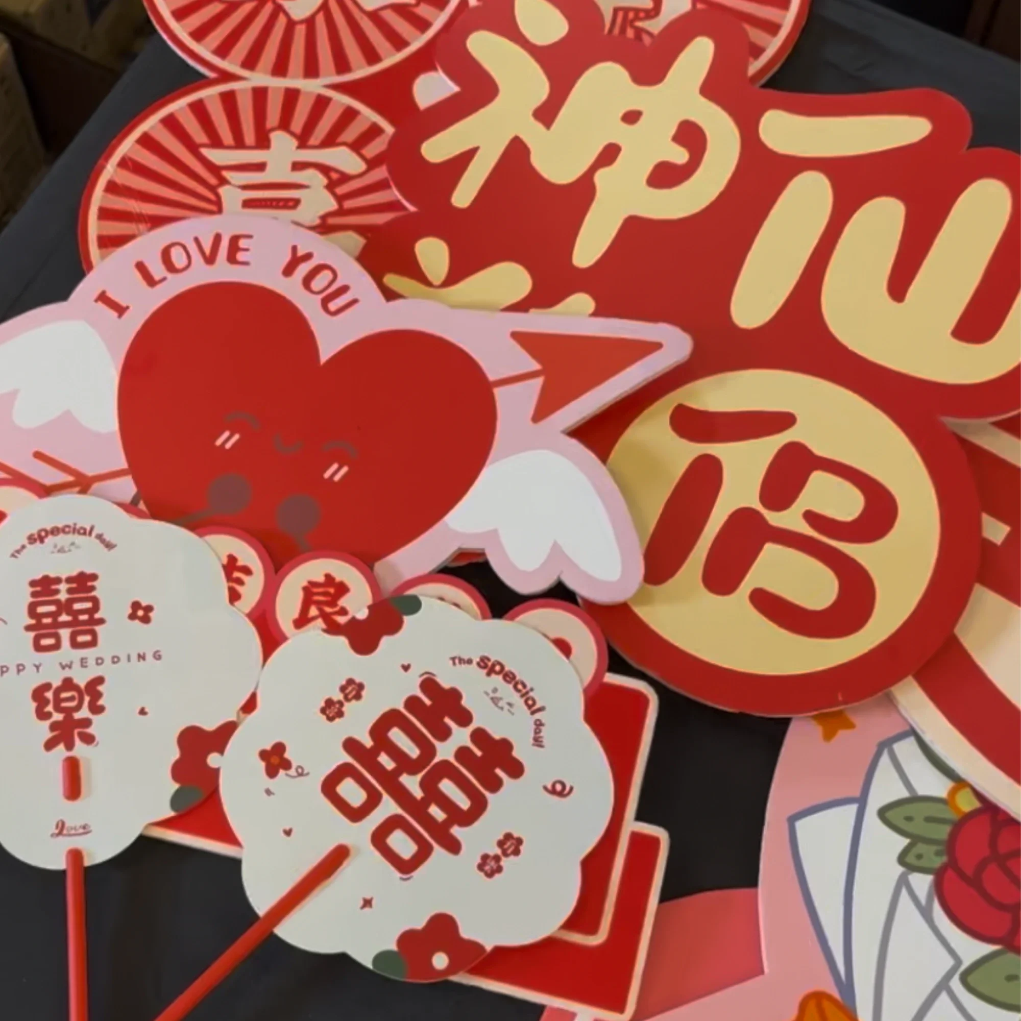 Red and white Valentine's Day themed paper decorations with hearts, Chinese characters, and romantic messages like 'I Love You' and 'Happy Wedding'.