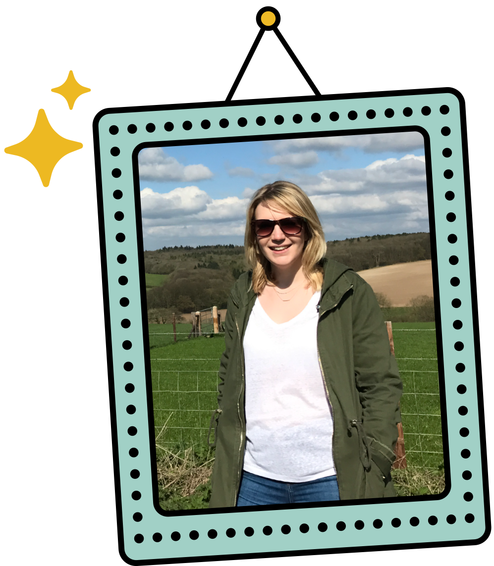 Photo of the designer Gem wearing sunglasses and a green jacket standing outdoors in front of a farm landscape with green fields, fencing, and rolling hills under a cloudy sky, sitting in an illustrated rectangle photoframe hanging on a wall.