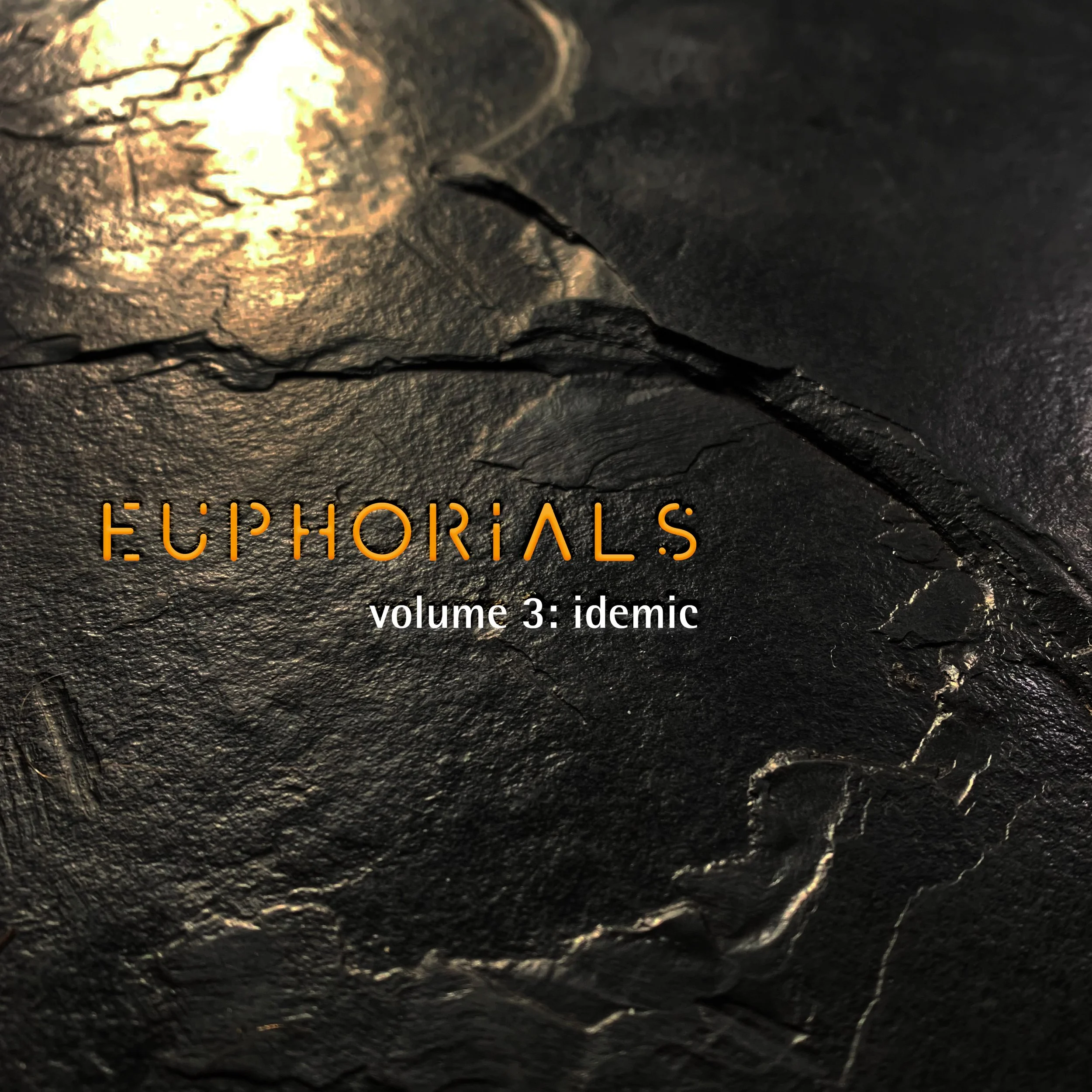 Close-up of a dark textured surface with metallic gold accents, featuring the text 'EUPHORIALS volume 3: idemic' in orange and white font.