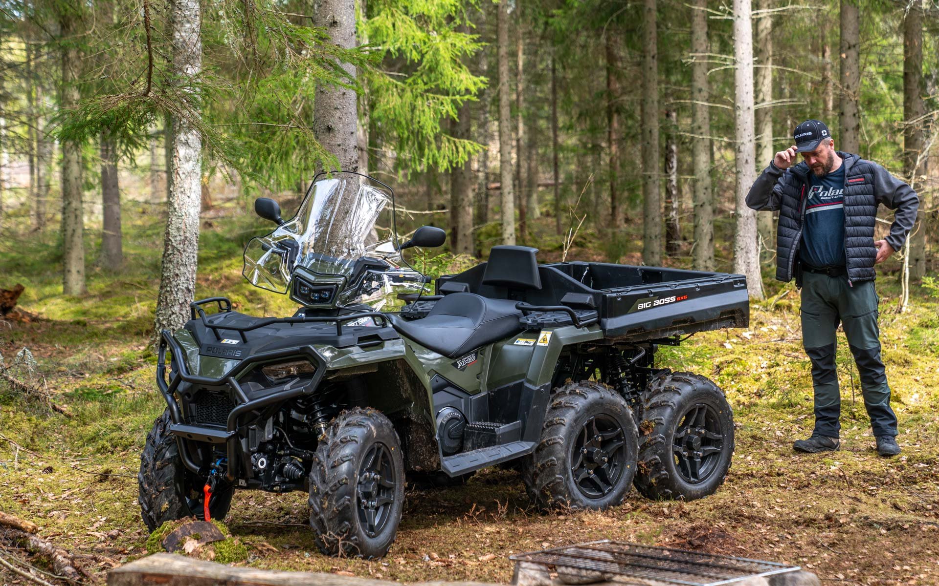 Polaris Sportsman 570 6x6 i en skog med träd och grön mossig mark