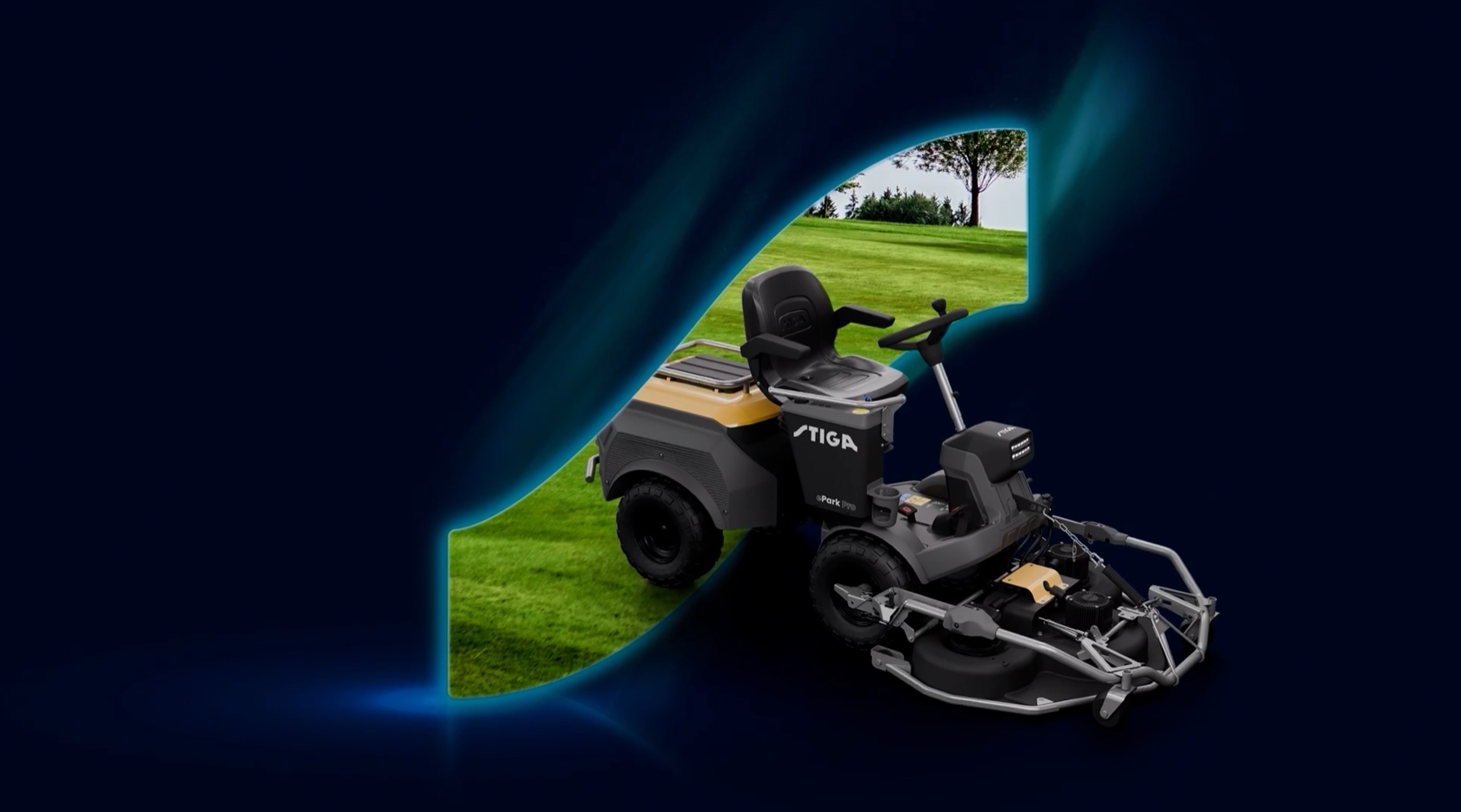 En Stiga Park med förarhytt som klipps grönt gräs, utsikt av träd och blå himmel i bakgrunden.