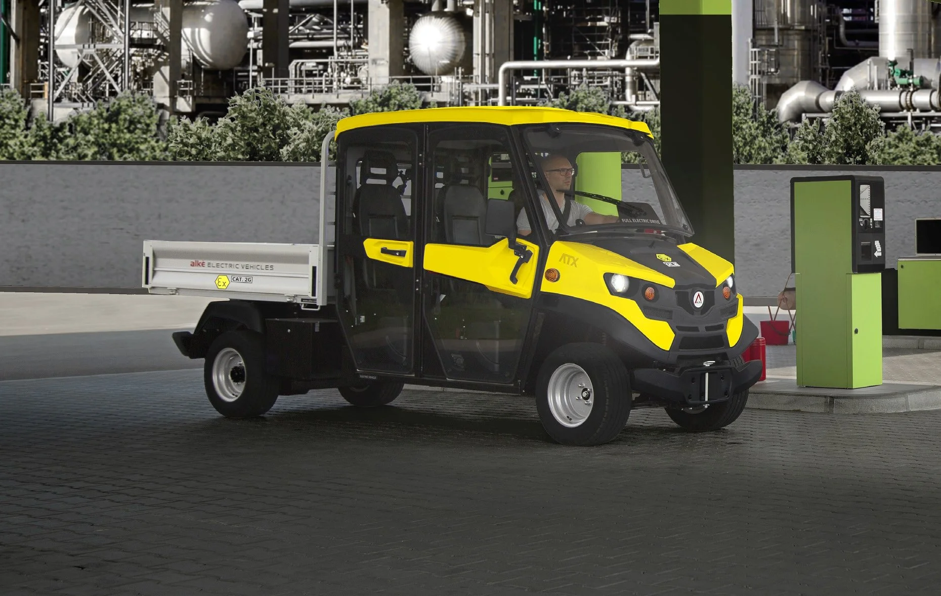 En gul och svart elektrisk Alkè ATEX vid en laddstation, med en man som kör den.