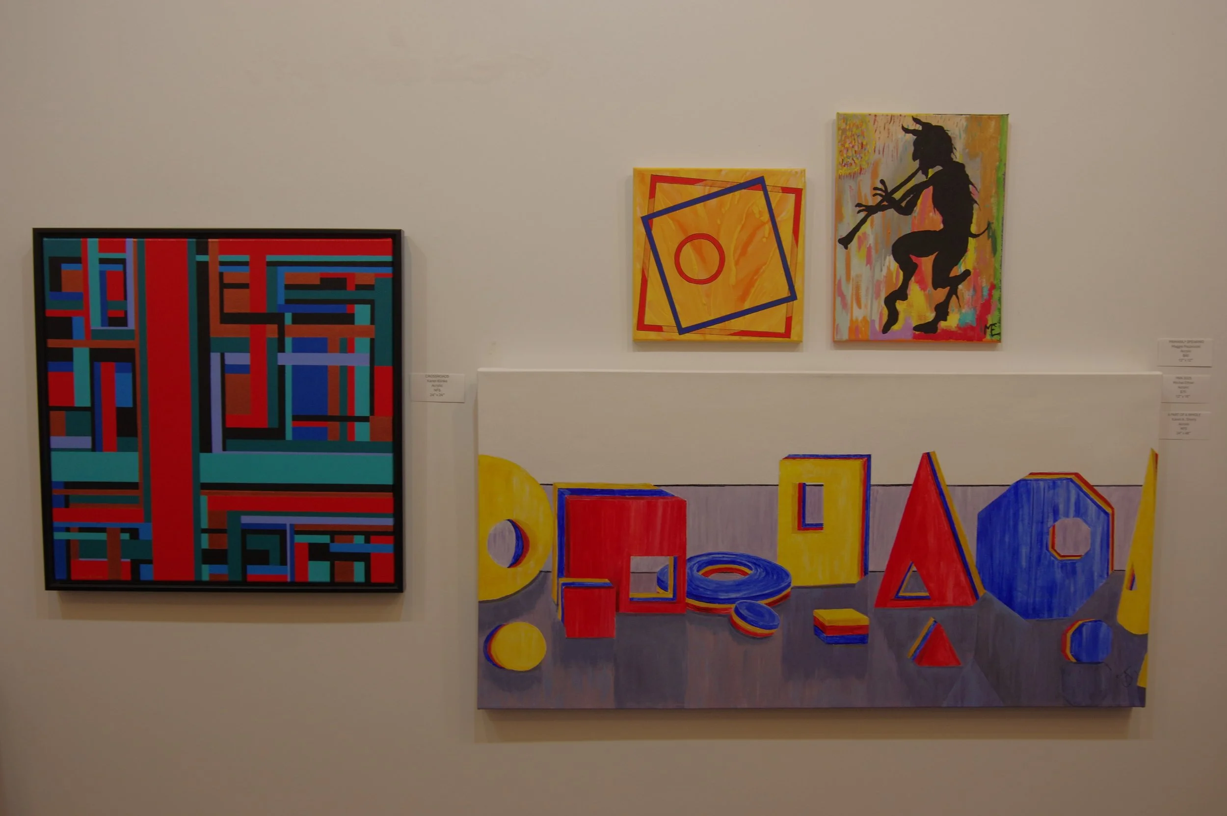 Exhibition wall with four colorful abstract paintings, including geometric patterns and a silhouette of a dancing figure.