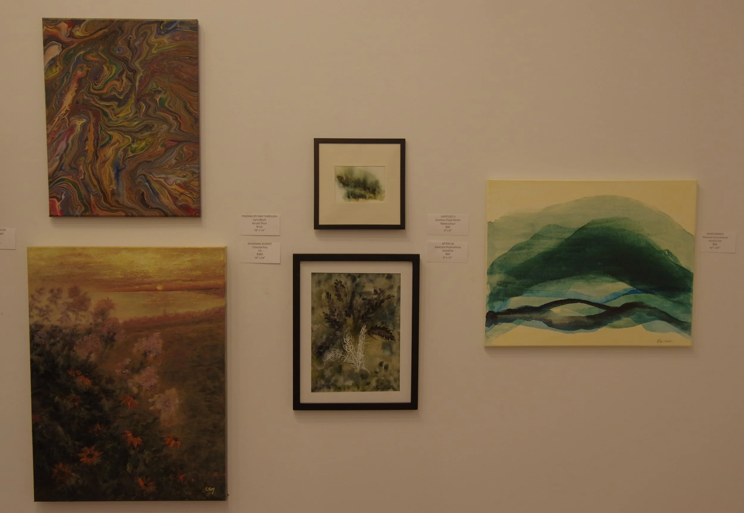 Five paintings hanging on a white gallery wall, including abstract and landscape scenes.