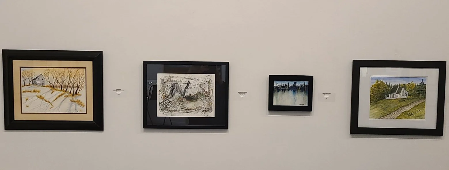 Four framed landscape paintings hung on a white gallery wall.