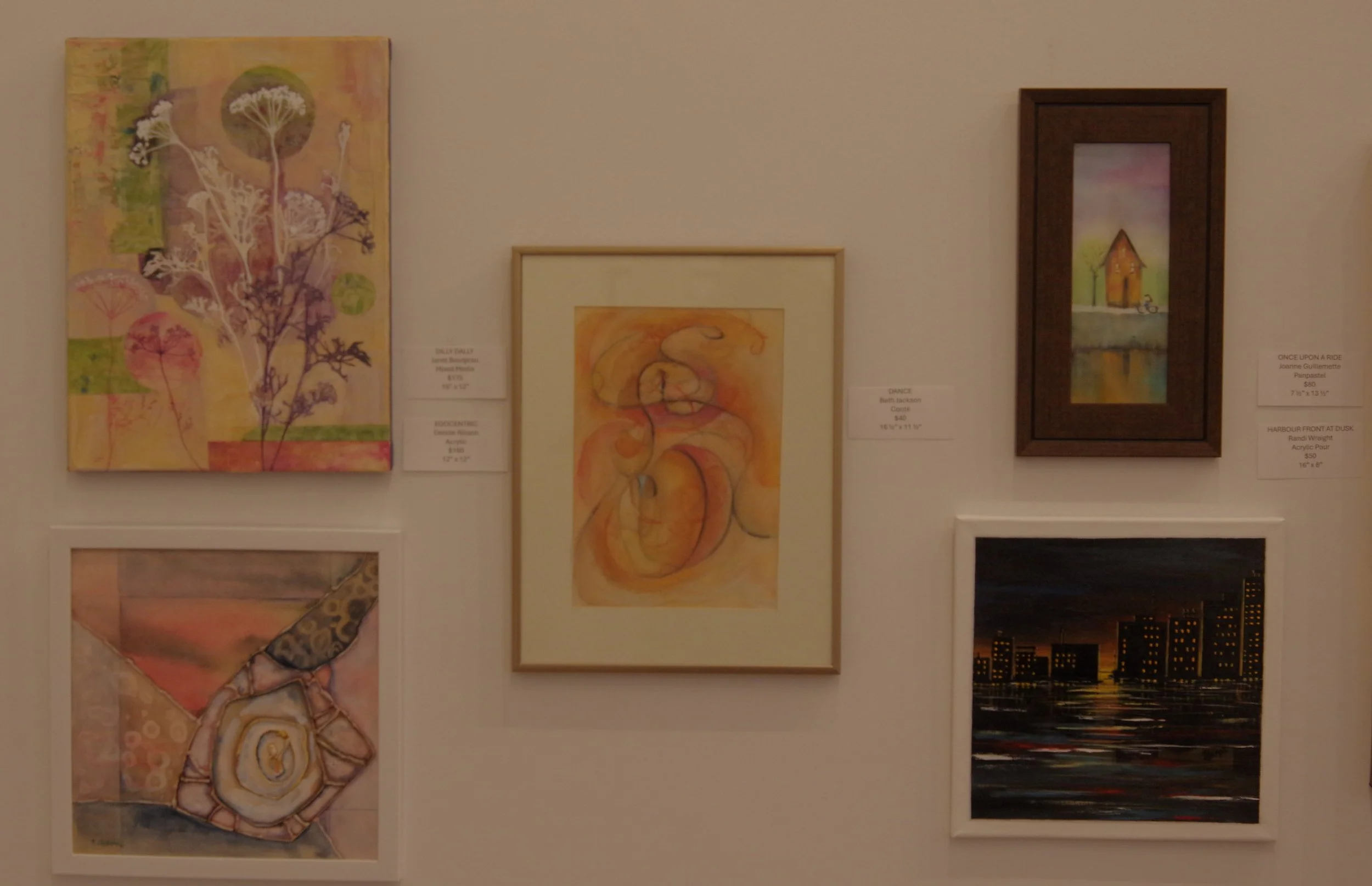 Six watercolor and oil paintings displayed on a white gallery wall, including ABSTRACT DISPLAY, OCKERTIME, DANCE, ONCE UPON A RIDE, HARBOUR FRONT AT DUSK, and an unidentified cityscape at sunset.