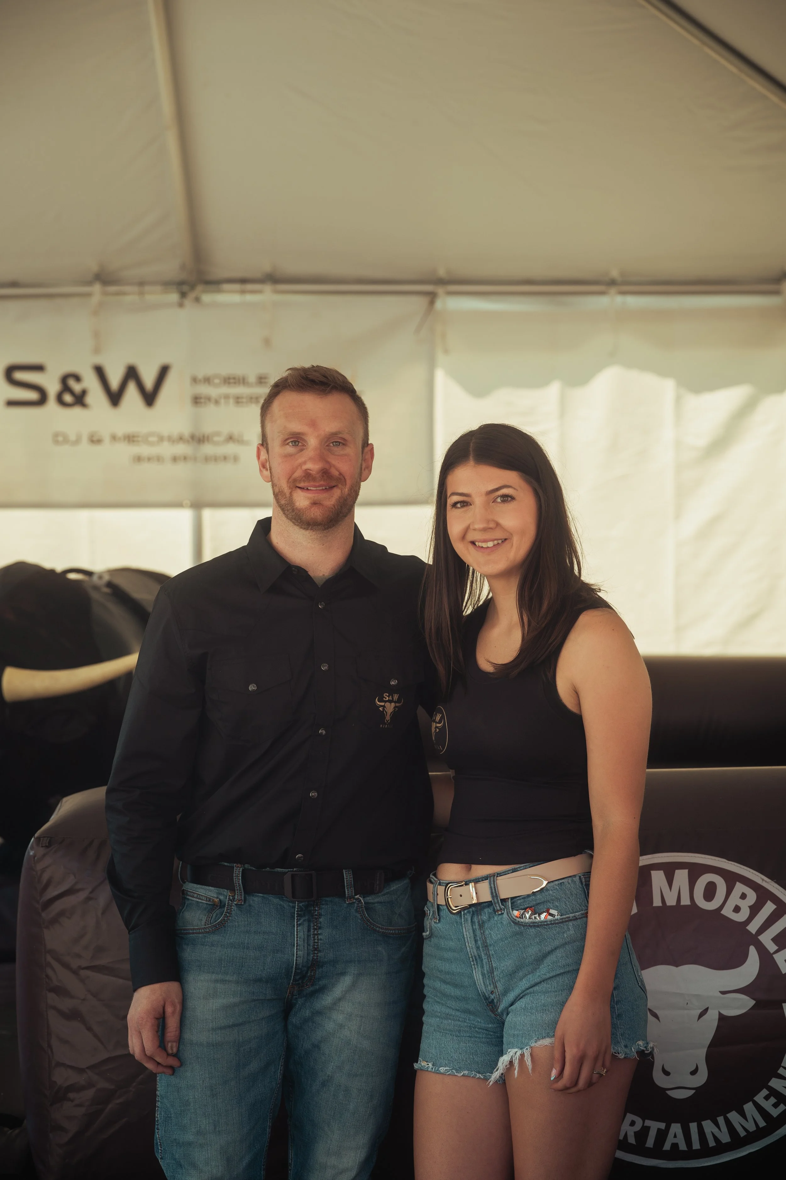 Will and Sarah, the owners of S&W Mobile Entertainment. Posing for a picture in front of their mechanical bull underneath their 20x30 enclosed tent at a public event in Dutchess County New York.
