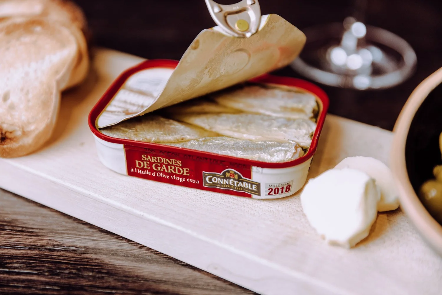 Dosen mit sardinen "Sardines de Garde" auf einem Holzbrett