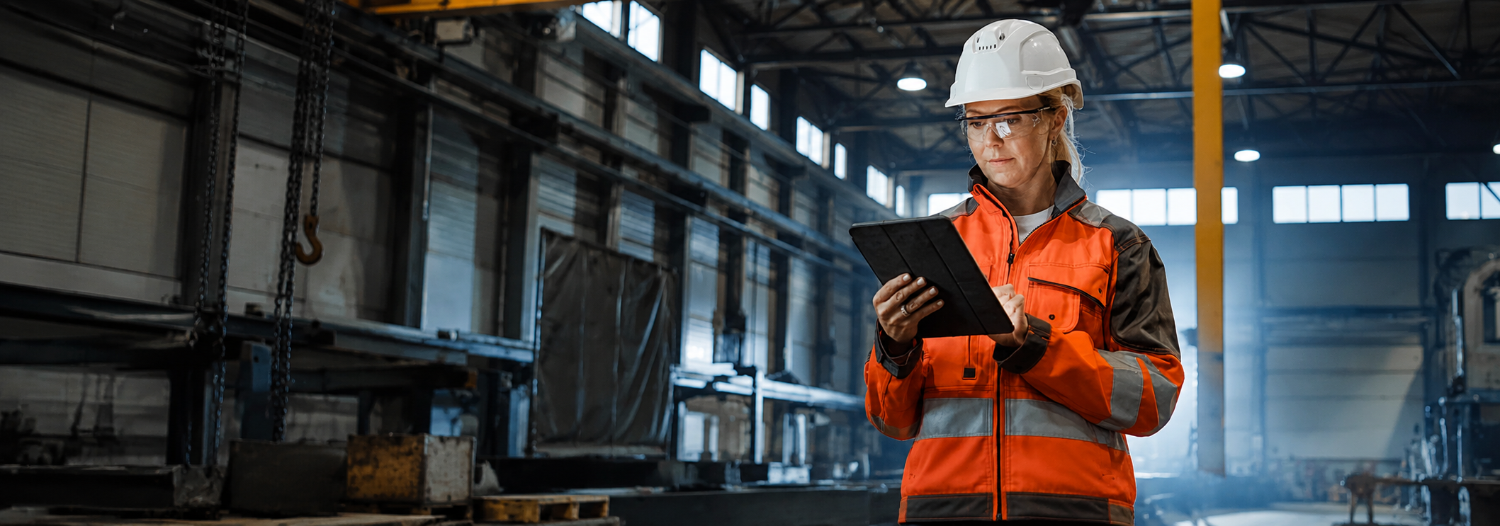 Woman in industrial warehouse looking at tablet