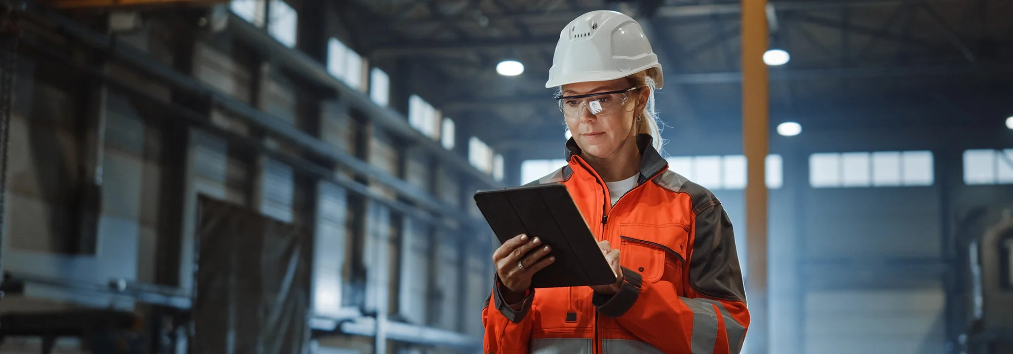 Woman in industrial warehouse looking at tablet