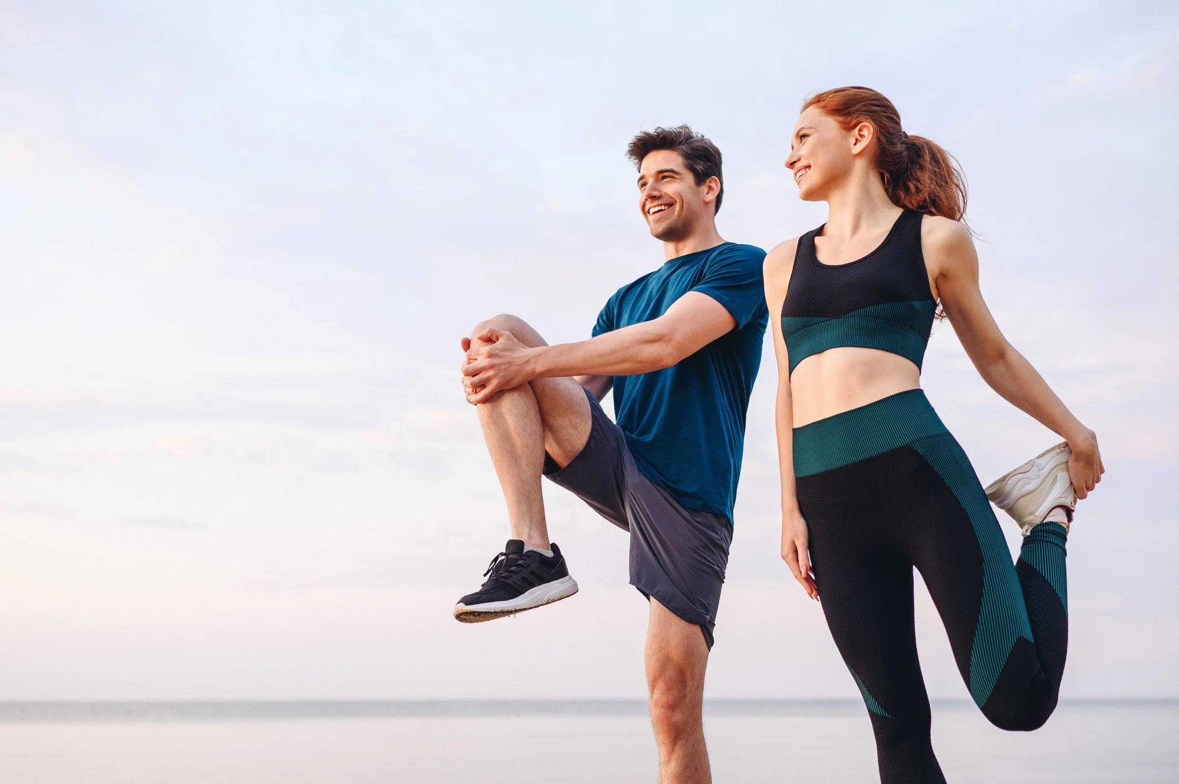 Man and women stretching before going on a run outside