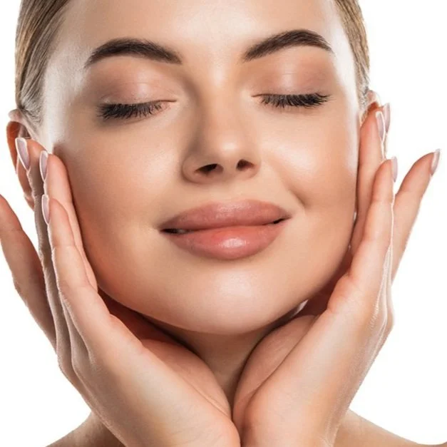 Close-up of a woman with clear skin gently touching her face with her hands, eyes closed, with a calm expression.