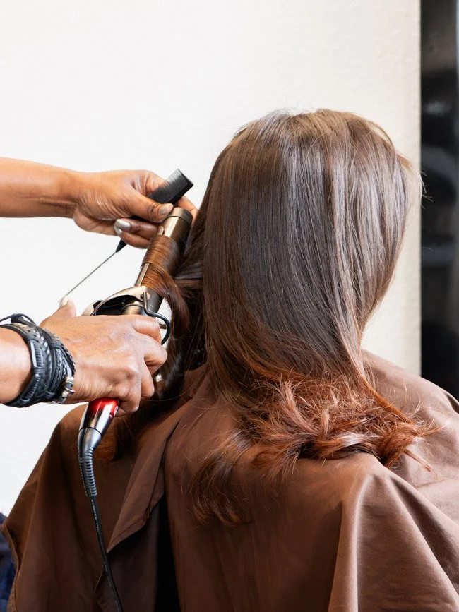 A person getting their hair blow-dried at a salon.