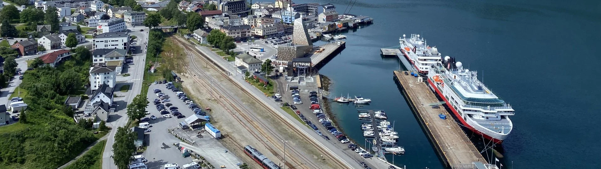 Oversiktsbilde av Tindekaia i Rauma. En stor båt ligger til havn, og du ser kaia, småbåthavna, og litt av sentrum i Åndalsnes