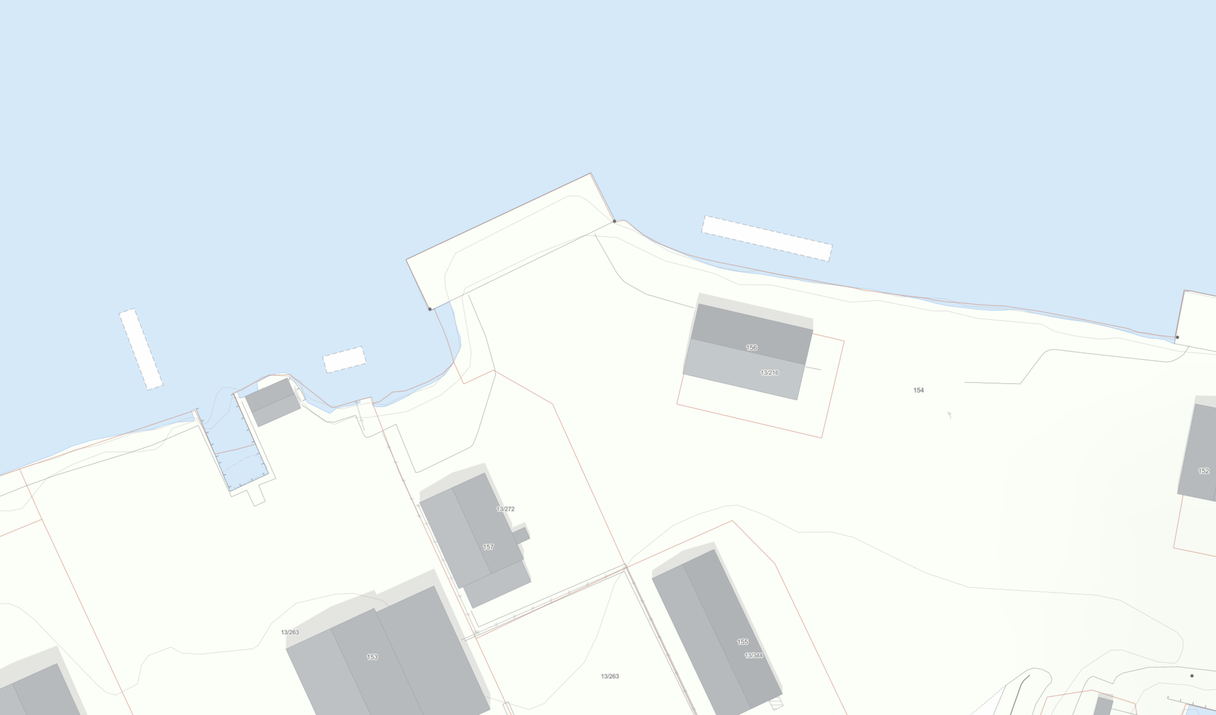 Kart som viser en eiendom ved vannet med grå bygninger, eiendomsnumre og vannkropp i bakgrunnen.