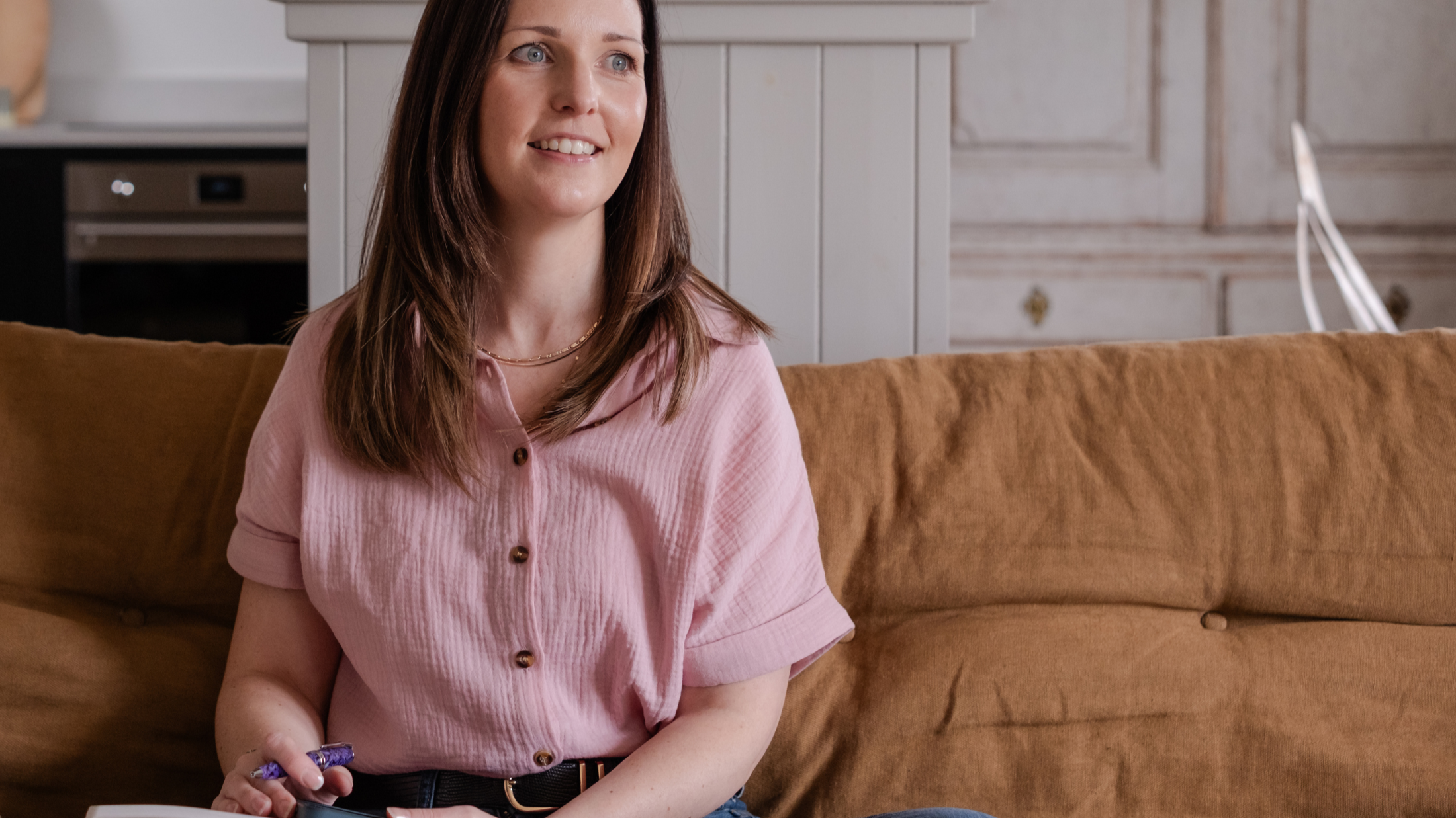 Genna Nelson nutritional therapist and genetic nutritionist, seated on an orange sofa in a calm setting