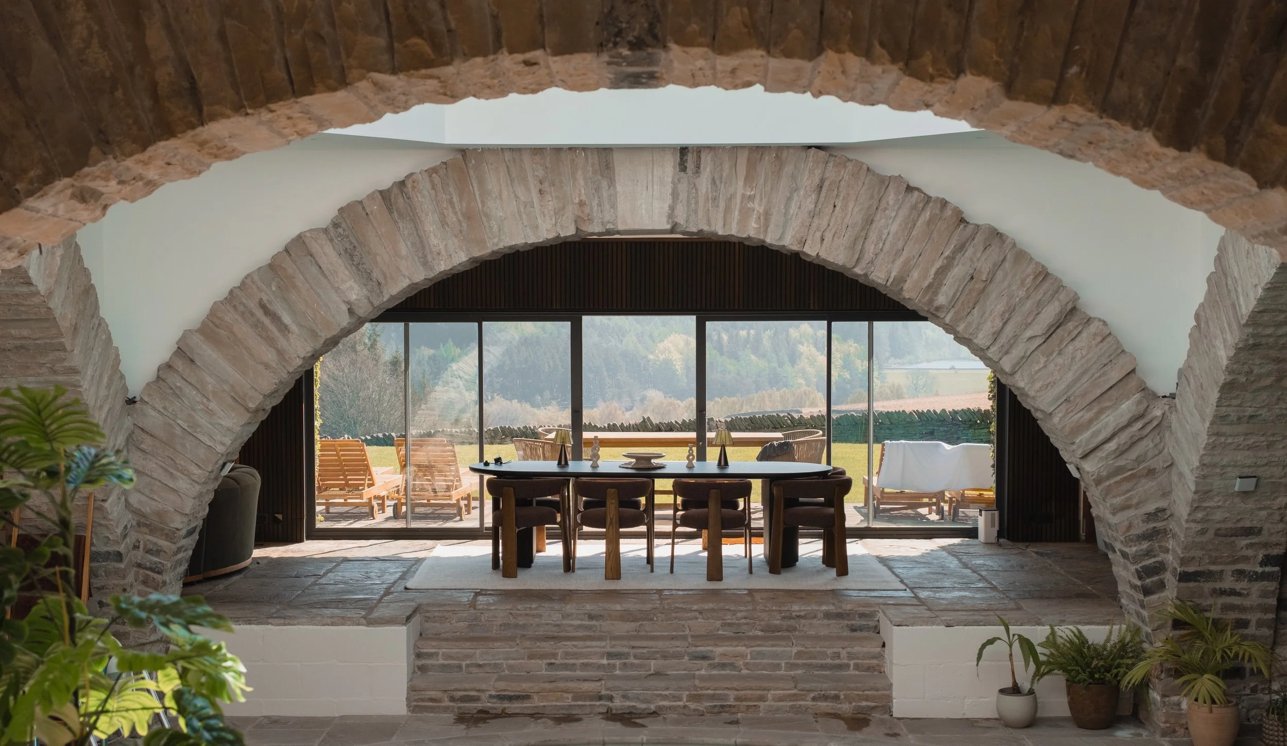 Dine beneath Underhill’s magnificent stone arches, with floor-to-ceiling windows opening onto the private garden and countryside beyond.