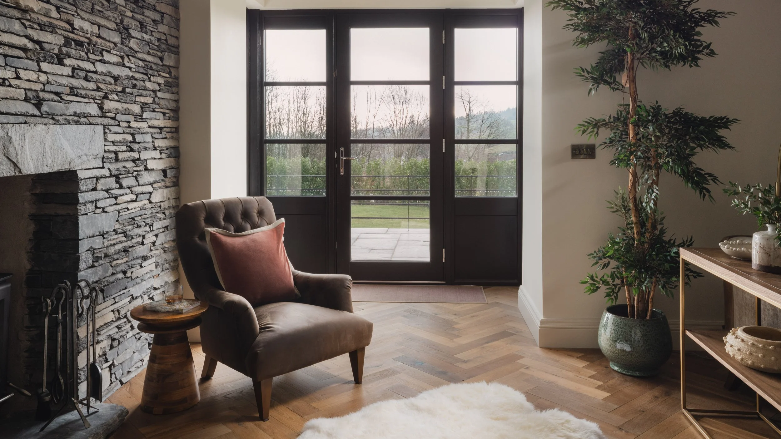 Welcoming you inside, the entrance blends natural textures and warm tones, with a stone fireplace and soft seating creating an inviting first impression.