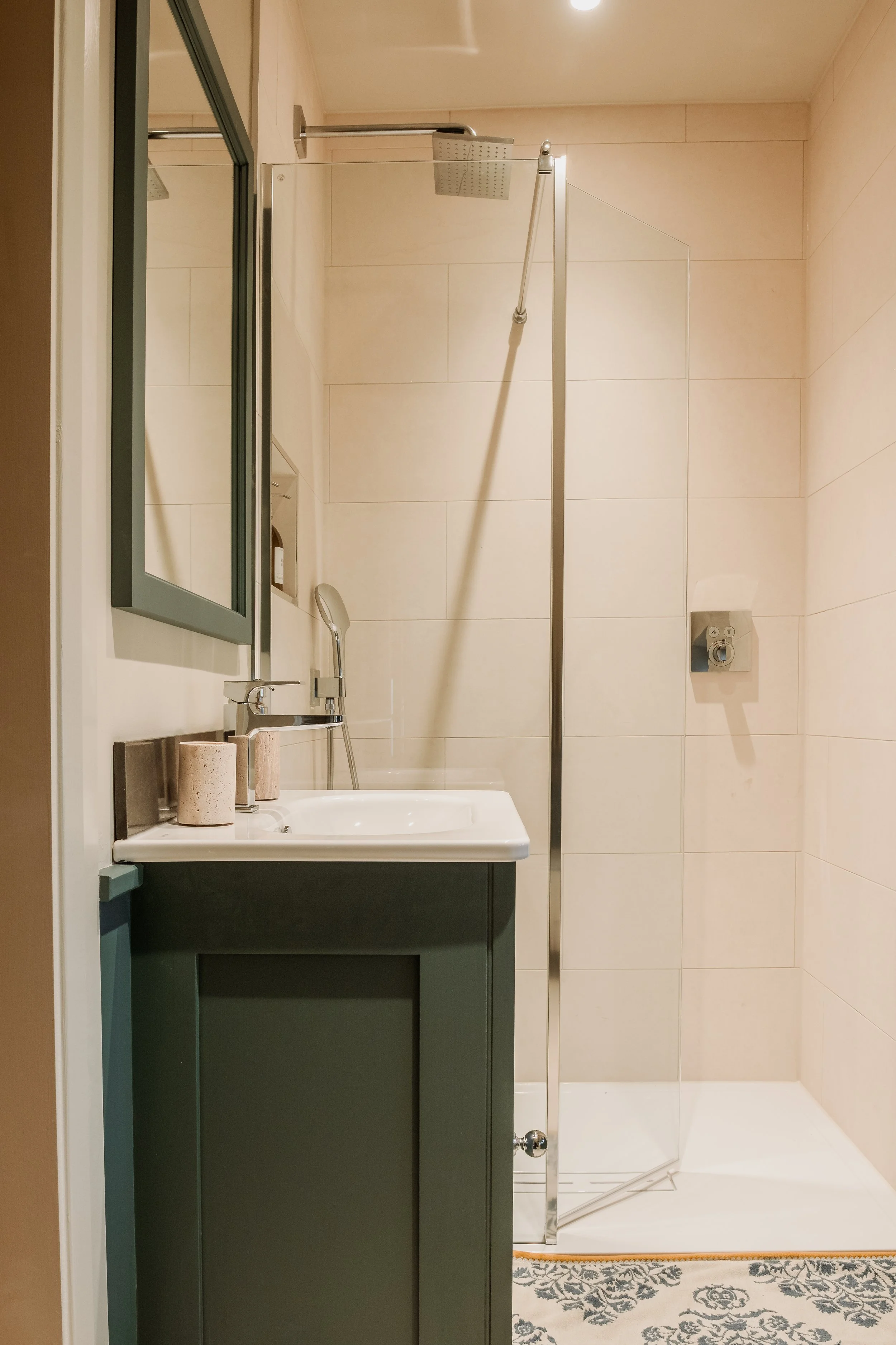 the ensuite continues the sense of calm with clean lines, soft neutrals, and a luxurious rainfall shower — a quiet, spa-like space designed for slow mornings and effortless unwinding.