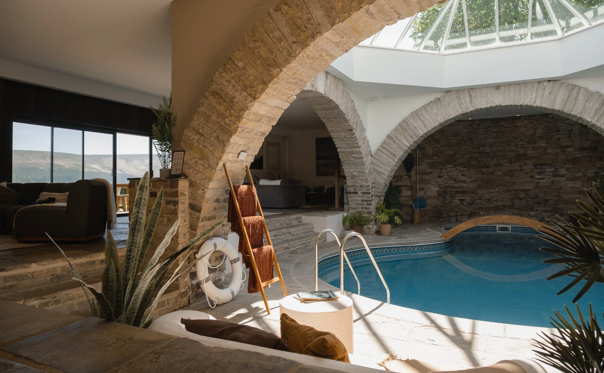where striking stone arches, a sculptural wooden bridge and an overhead skylight create a truly unique setting.