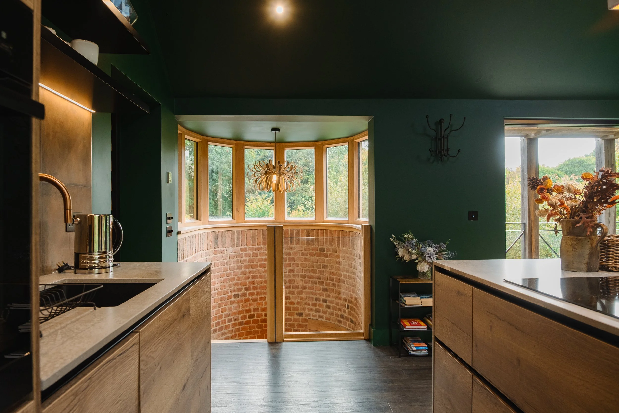 The sculptural staircase unfolds through light and shadow, framing ever-changing views of the surrounding woodland.