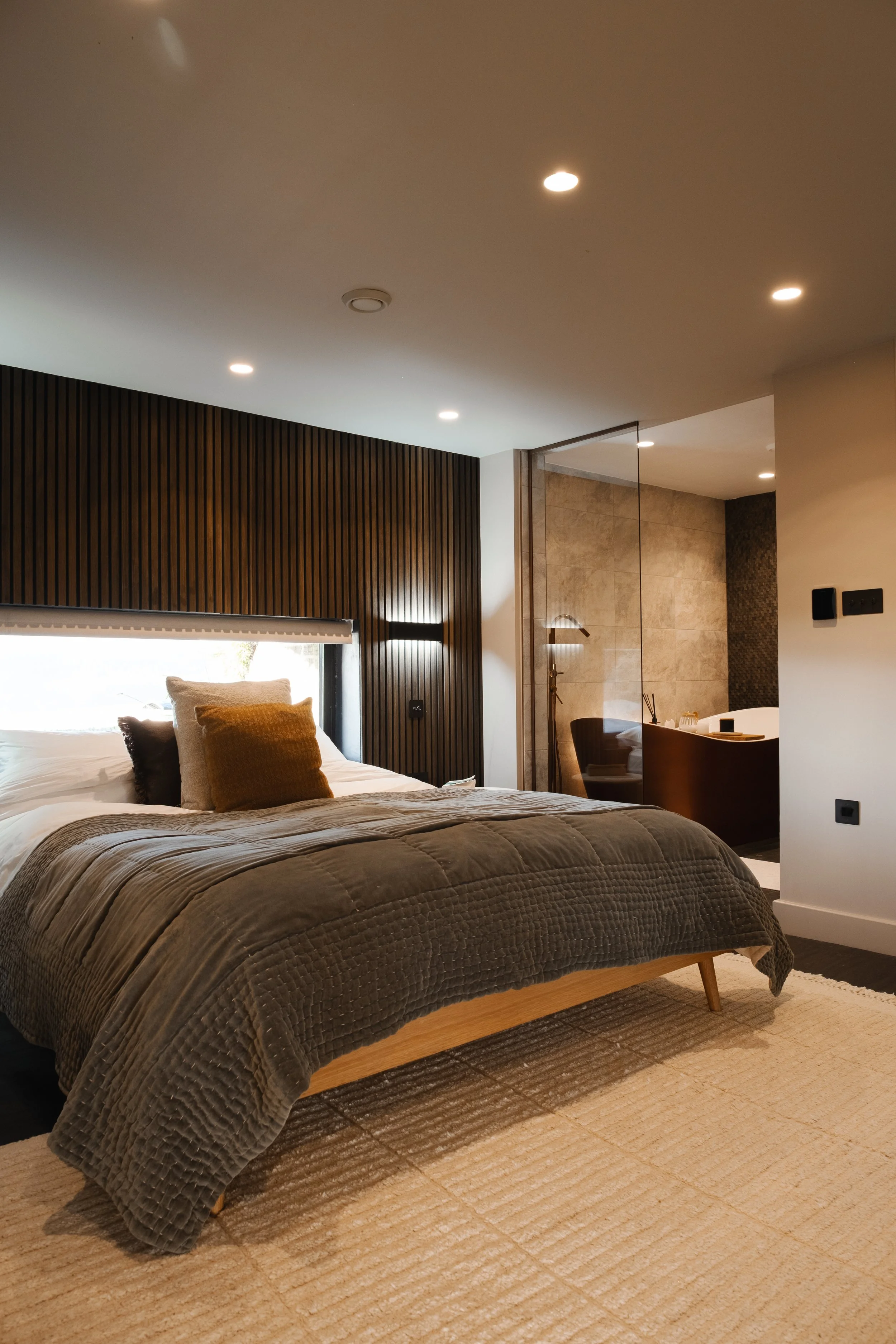 Retreat to Underhill’s luxurious master bedroom, styled in rich, calming tones with a sumptuous bed and contemporary en-suite bathroom.