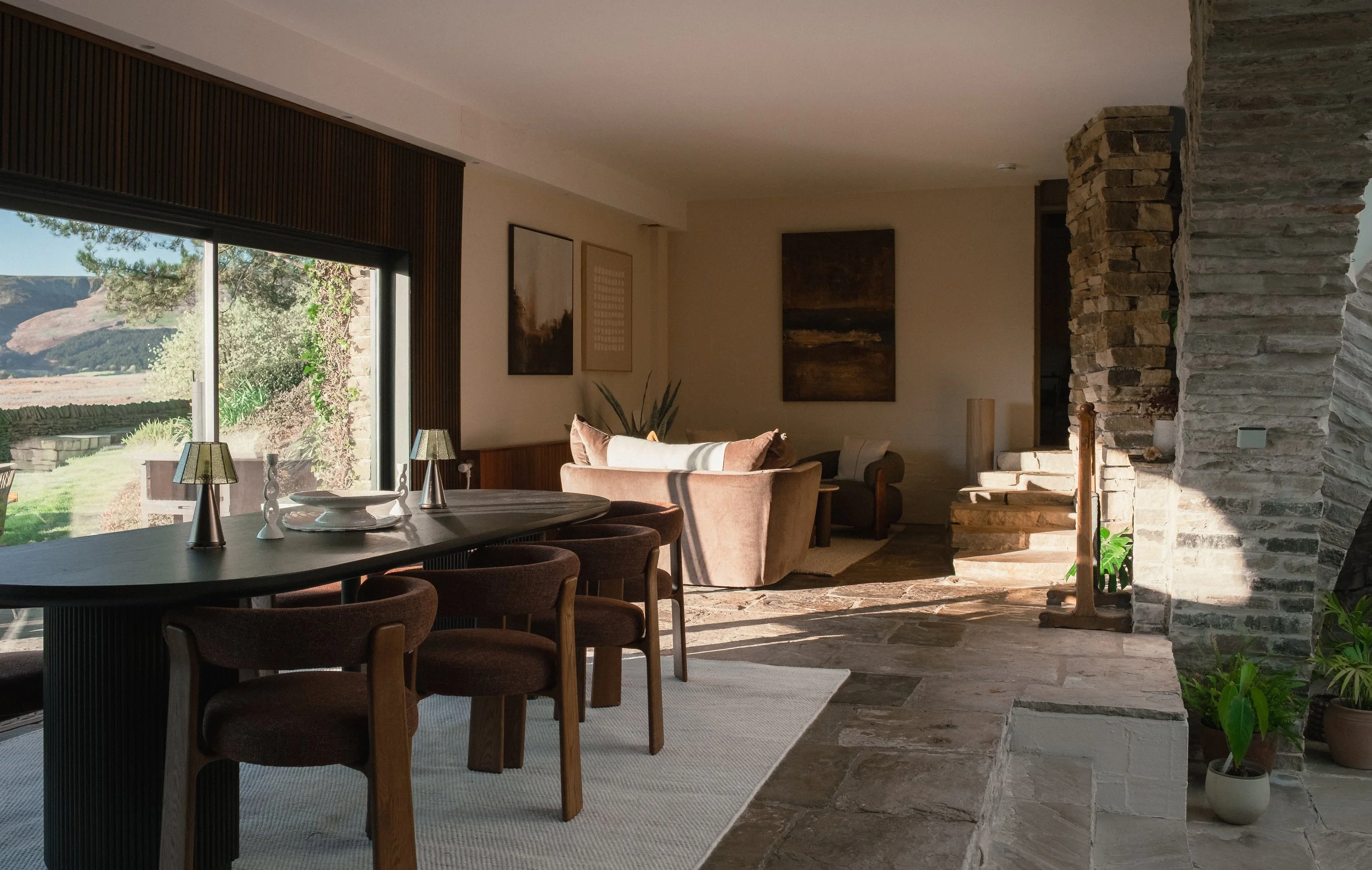 Gather together in Underhill’s spacious open-plan dining and living area, where warm furnishings, original stonework and expansive windows create an inviting place to unwind.